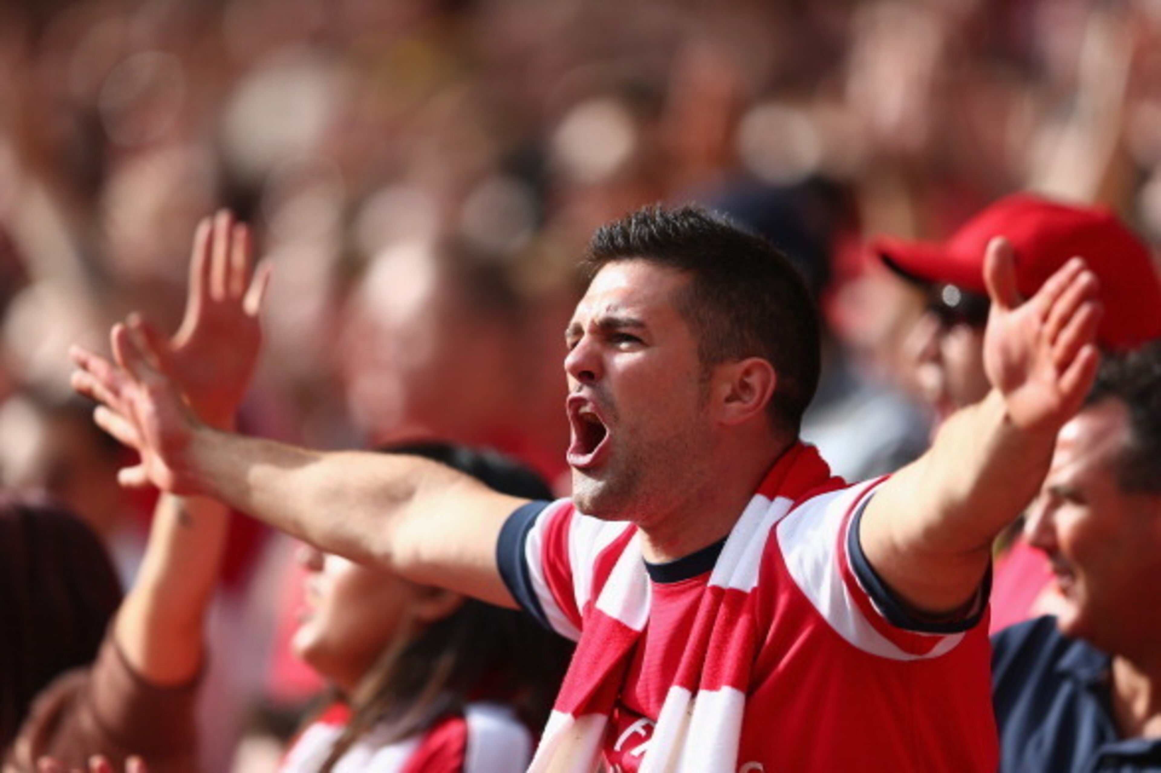 LONDON, ENGLAND - SEPTEMBER 01:  An Arsenal fans cheers his team during the Barclays Premier League match between Arsenal and Tottenham Hotspur at Emirates Stadium on September 01, 2013 in London, England.  (Photo by Clive Mason/Getty Images)