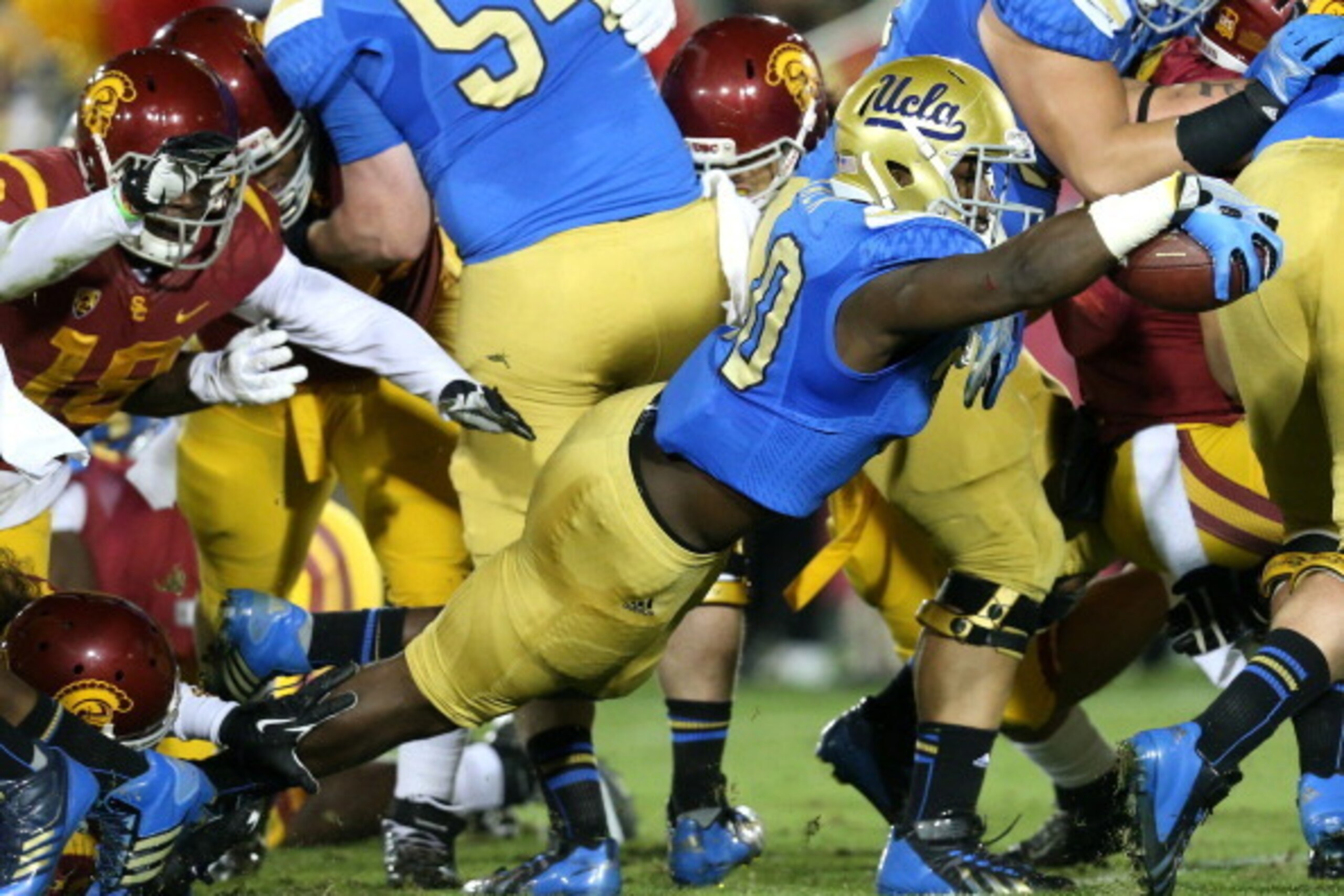 LOS ANGELES, CA - NOVEMBER 30: Myles Jack #30 of the UCLA Bruins dives into the end zone on a three yard touchdown carry in the first quarter against the USC Trojans at Los Angeles Coliseum on November 30, 2013 in Los Angeles, California.  (Photo by Steph
