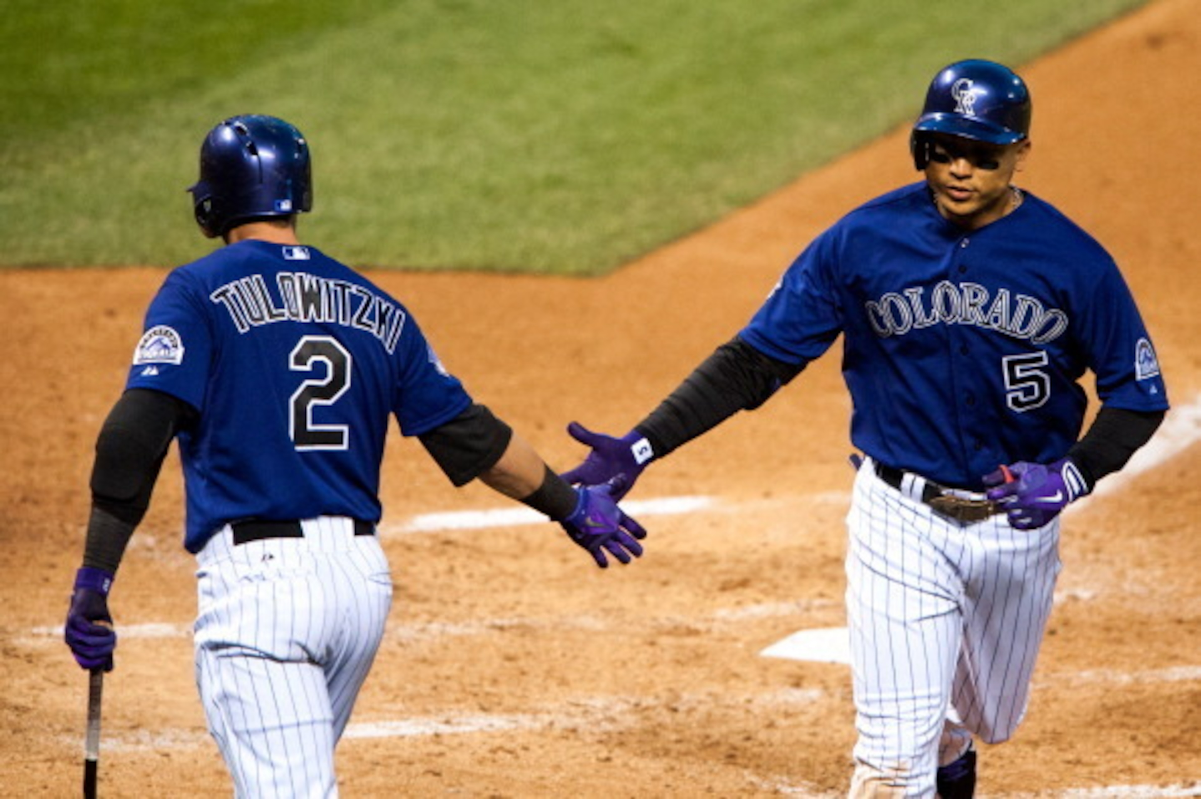 DENVER, CO - MAY 4:  Carlos Gonzalez #5 of the Colorado Rockies celebrates a solo home run with Troy Tulowitzki #2 during the fifth inning of a game against the Tampa Bay Rays at Coors Field on May 4, 2013 in Denver, Colorado.  (Photo by Dustin Bradford/G
