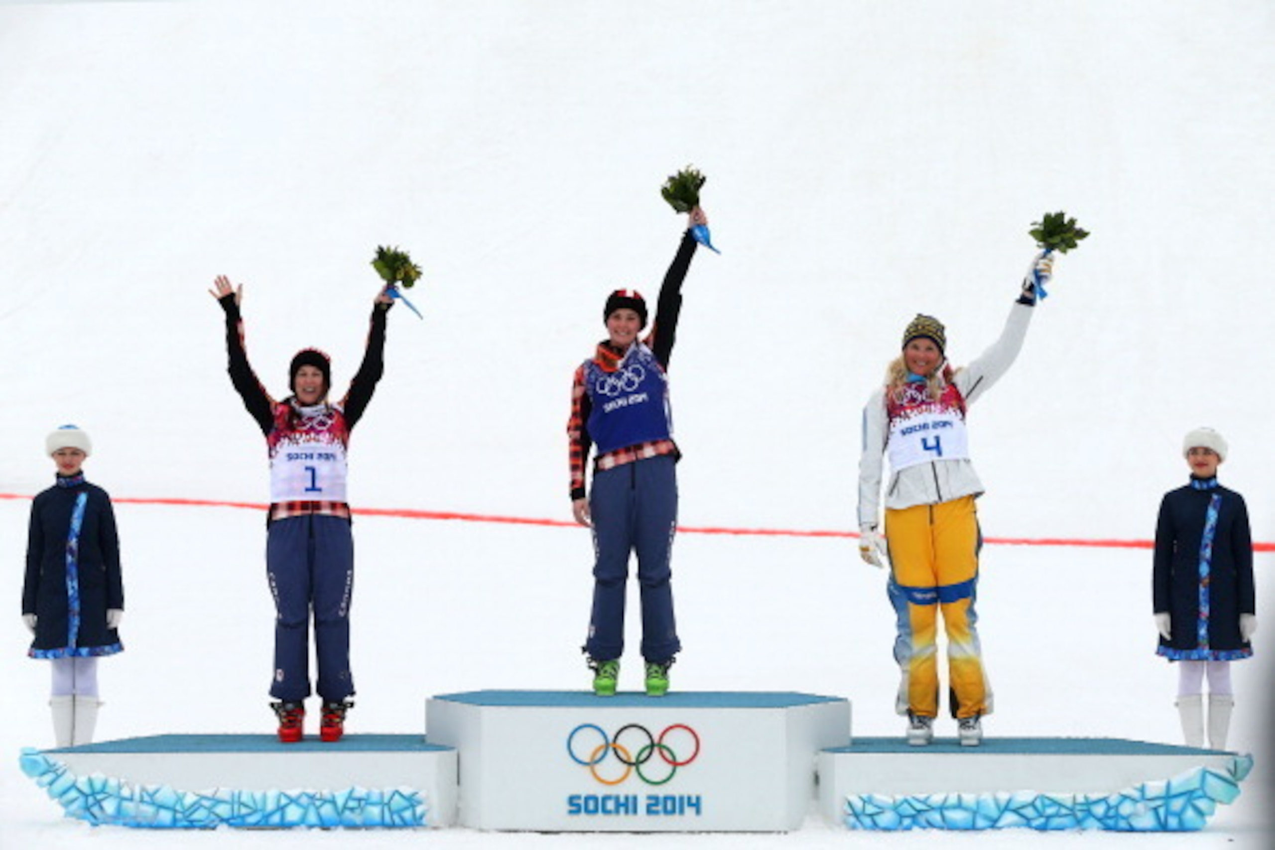 SOCHI, RUSSIA - FEBRUARY 21:  Marielle Thompson (C) of Canada celebrates winning the gold medal with silver medalist Kelsey Serwa (L) of Canada and bronze medalist Anna Holmlund of Sweden during the flower ceremony in the Freestyle Skiing Womens' Ski Cros