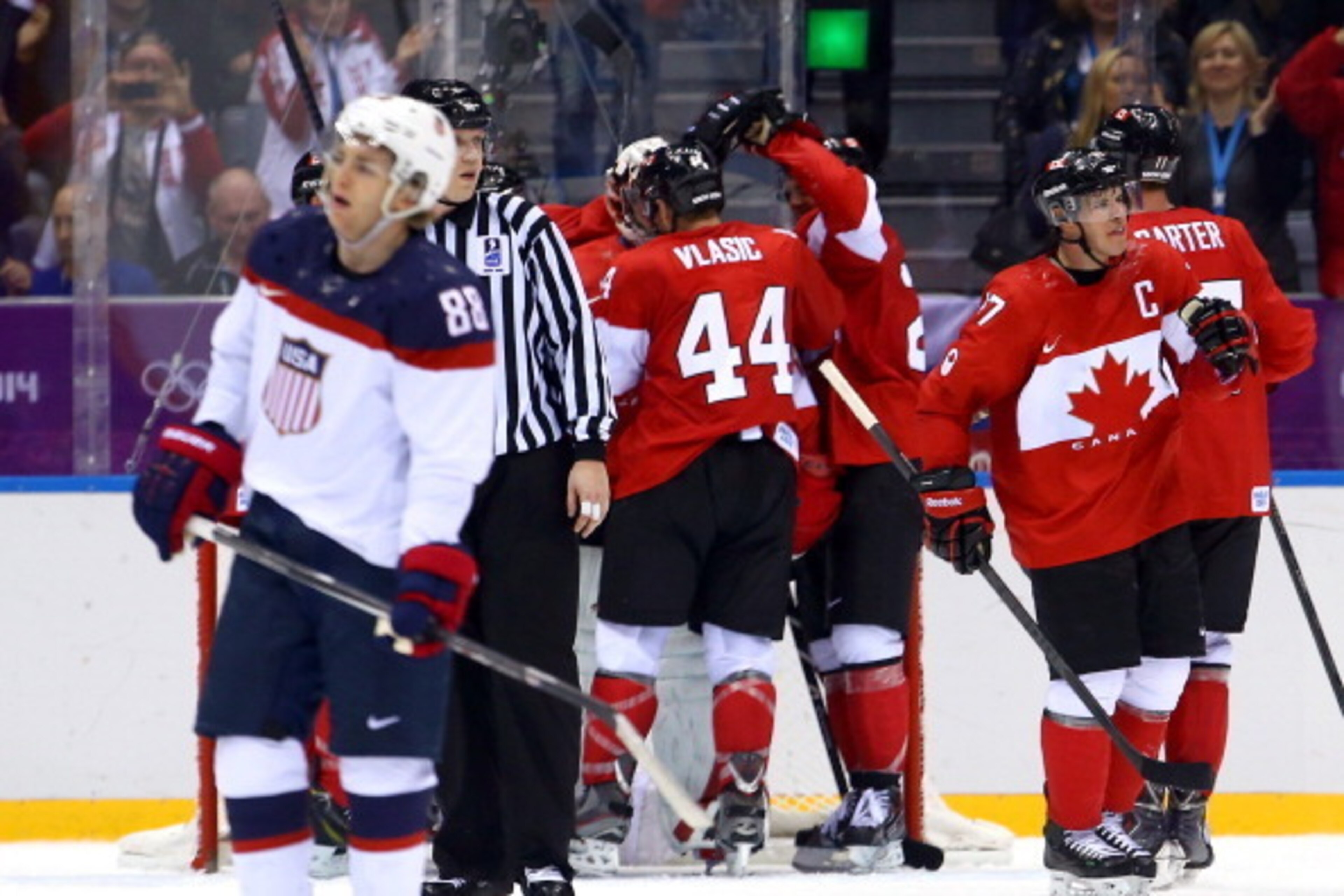 SOCHI, RUSSIA - FEBRUARY 21:  Patrick Kane #88 of the United States reacts after losing 1-0 to Canada as Marc-Edouard Vlasic #44, Sidney Crosby #87 and Jeff Carter #77 of Canada celebrate during the Men's Ice Hockey Semifinal Playoff on Day 14 of the 2014