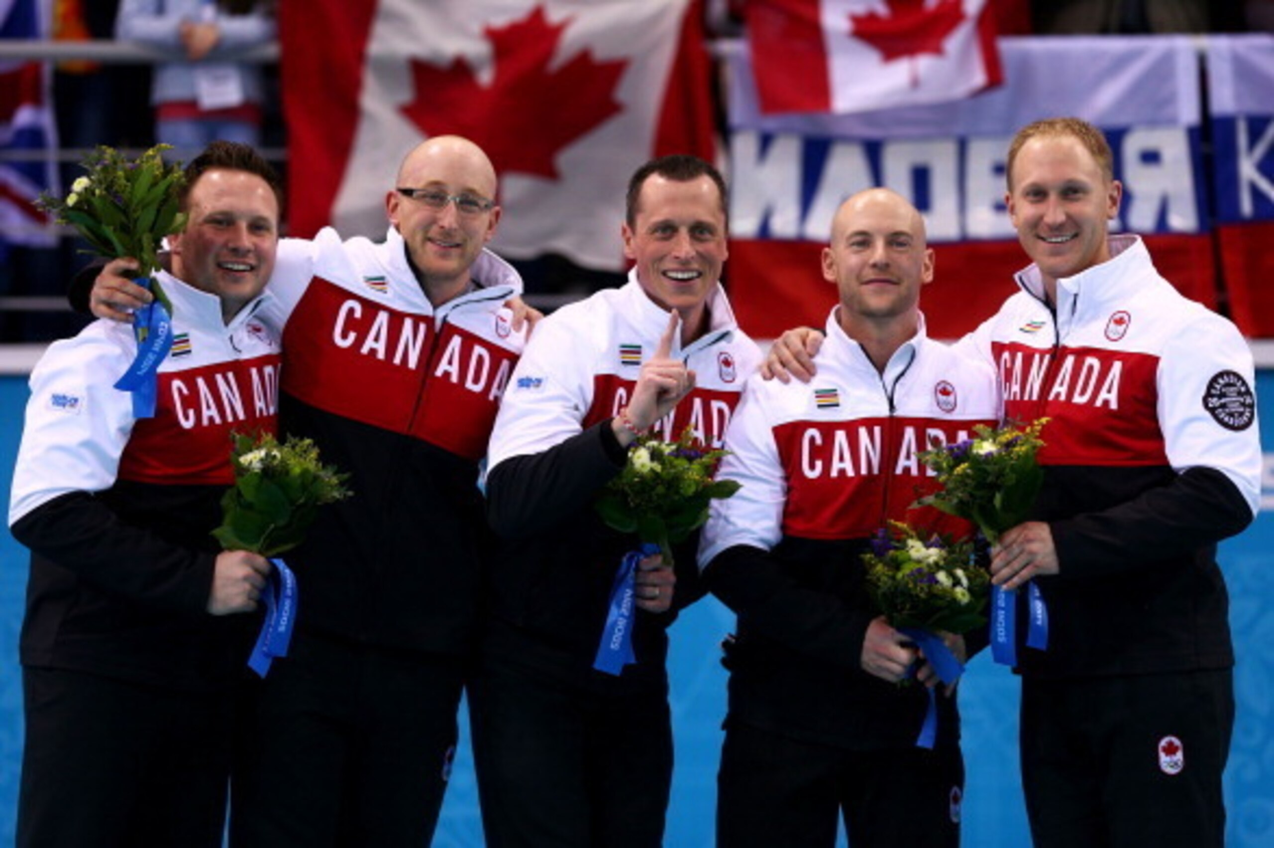 SOCHI, RUSSIA - FEBRUARY 21:  (L-R) Gold medalists Caleb Flaxey, Ryan Harnden, EJ Harnden, Ryan Fry and Brad Jacobs of Canada celebrate during the flower ceremony for the Men's Gold Medal match between Canada and Great Britain on day 14 of the Sochi 2014 