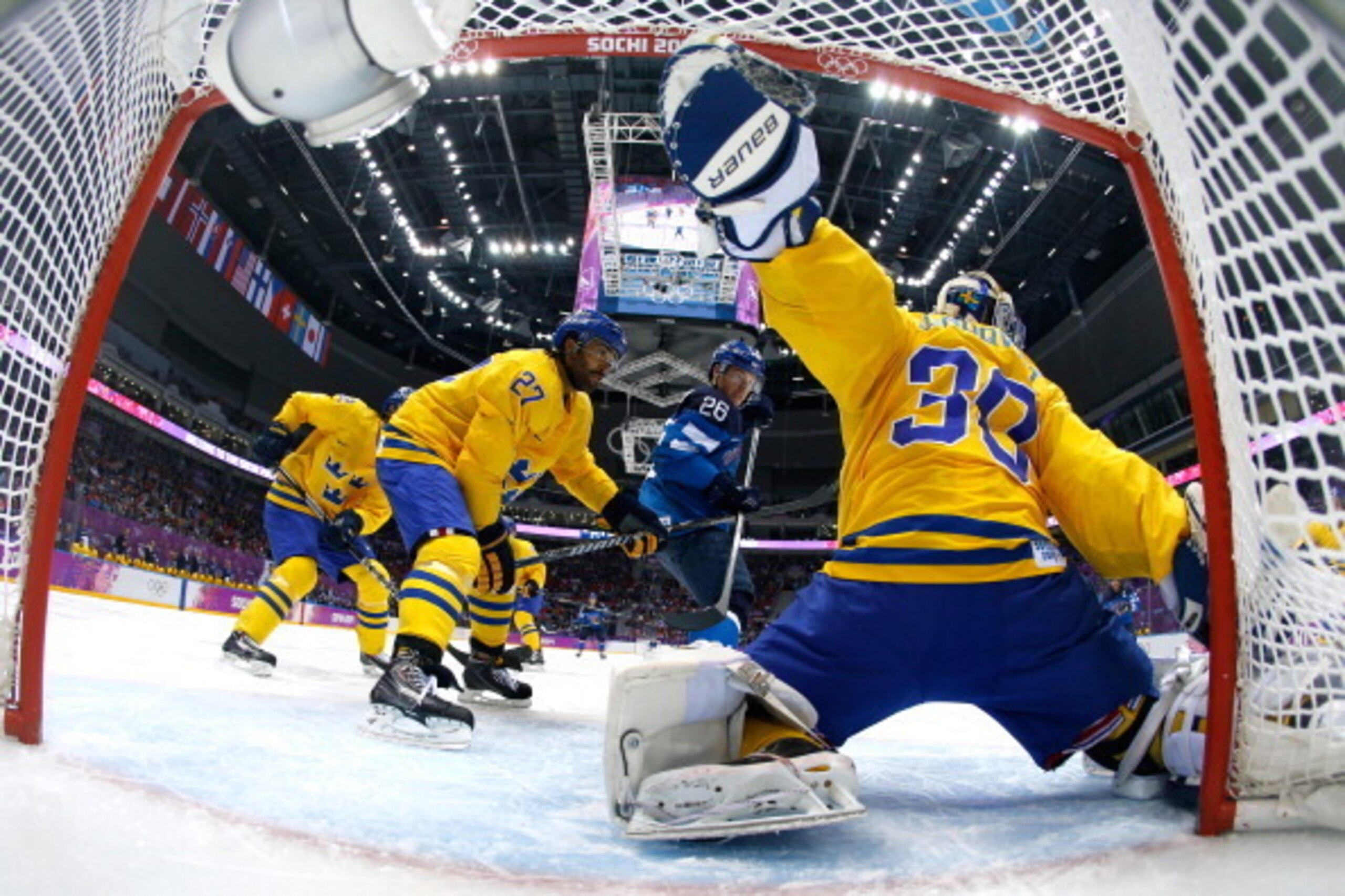 SOCHI, RUSSIA - FEBRUARY 21:  Henrik Lundqvist #30 of Sweden makes a save as Jarkko Immonen #26 of Finland looks on during the Men's Ice Hockey Semifinal Playoff on Day Twelve of the 2014 Sochi Winter Olympics at Bolshoy Ice Dome on February 21, 2014 in S