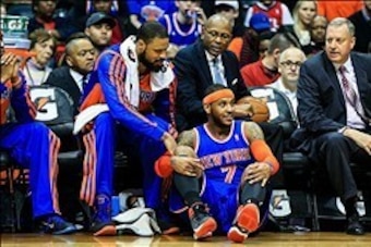 Feb 22, 2014; Atlanta, GA, USA; New York Knicks small forward Carmelo Anthony (7) falls into his teams' bench in the second half against the Atlanta Hawks at Philips Arena. The Hawks won 107-98. Mandatory Credit: Daniel Shirey-USA TODAY Sports