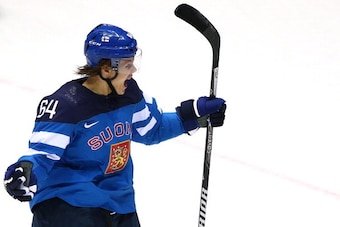 SOCHI, RUSSIA - FEBRUARY 19:  Mikael Granlund #64 of Finland celebrates after assisting on a first-period goal scored by teammate Teemu Selanne #8 against Russia during the Men's Ice Hockey Quarterfinal Playoff on Day 12 of the 2014 Sochi Winter Olympics 
