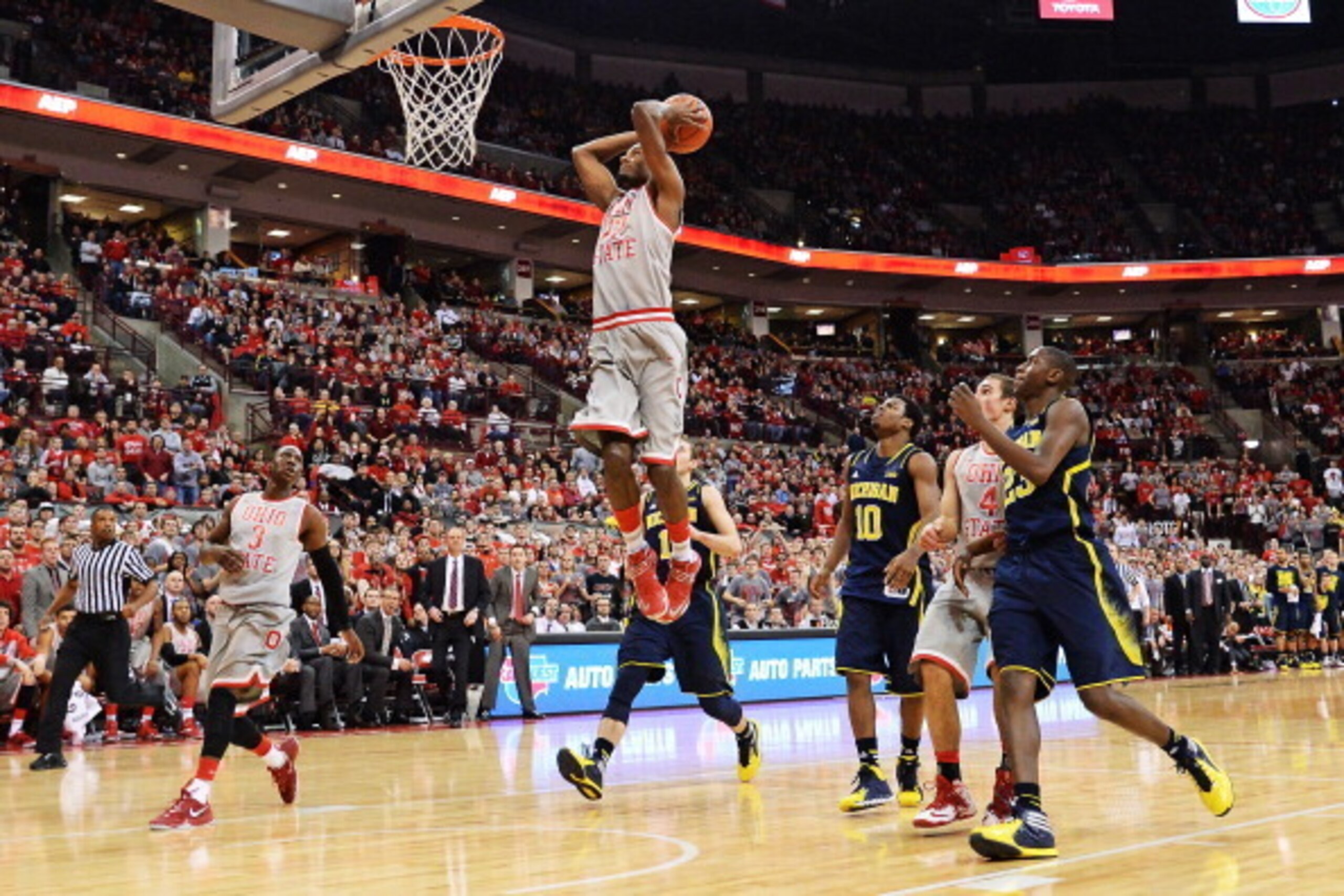 COLUMBUS, OH - FEBRUARY 11:  Sam Thompson #12 of the Ohio State Buckeyes finishes off a fast break in the second half against the Michigan Wolverines with a slam dunk on February 11, 2014 at Value City Arena in Columbus, Ohio. Michigan defeated Ohio State