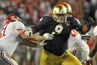 Jan 7, 2013; Miami, FL, USA; Notre Dame Fighting Irish defensive lineman Louis Nix III (9) fights off a block by Alabama Crimson Tide offensive linesman Anthony Steen (61) during the first half of the 2013 BCS Championship game at Sun Life Stadium.  Manda