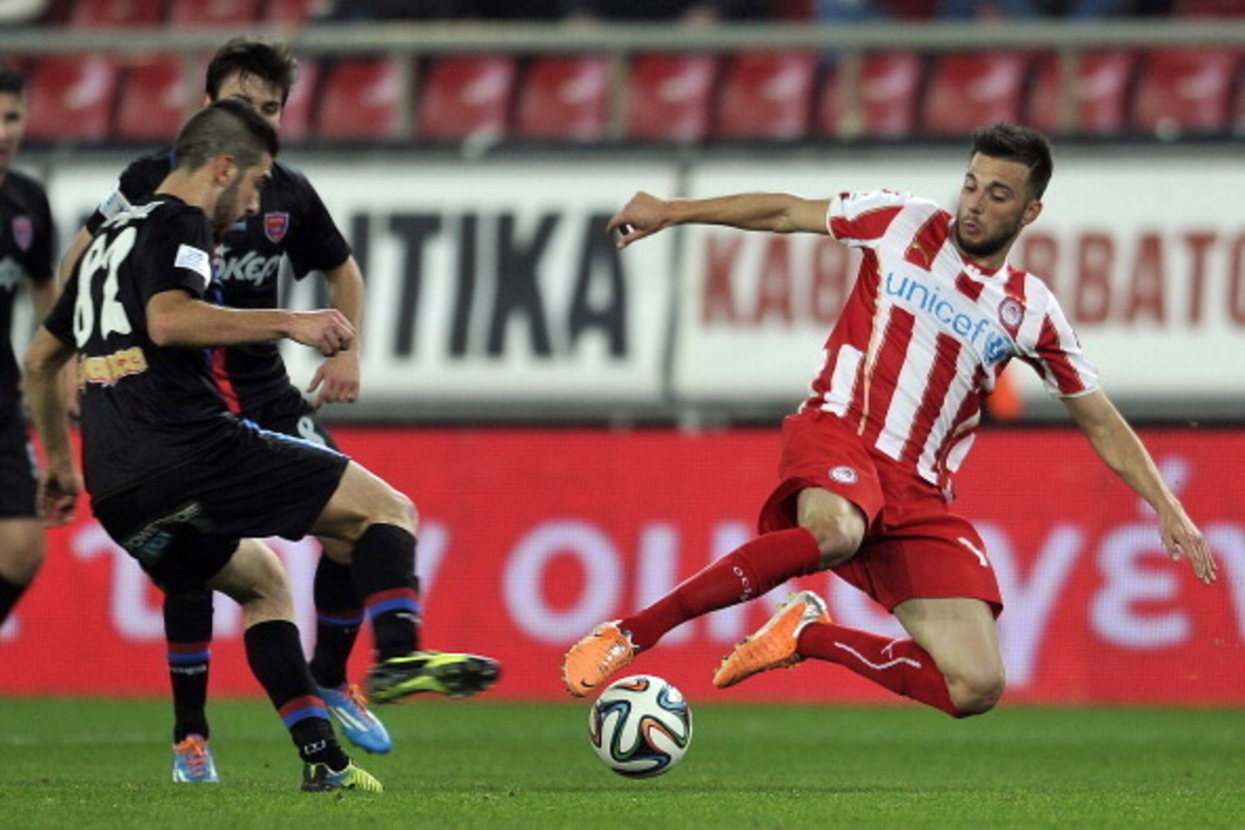 ATHENS,GREECE - FEBRUARY 5: Andreas Samaris of Olympiacos F.C. tackles Pavlos Mitropoulos of Panionios GSS during the Greek Superleague match between Olympiacos F.C. and Panionios GSS at the Karaiskaki Stadium on February 5, 2014 in Piraeus near Athens ATHENS,GREECE - FEBRUARY 5: Andreas Samaris of Olympiacos F.C. tackles Pavlos Mitropoulos of Panionios GSS during the Greek Superleague match between Olympiacos F.C. and Panionios GSS at the Karaiskaki Stadium on February 5, 2014 in Piraeus near Athens