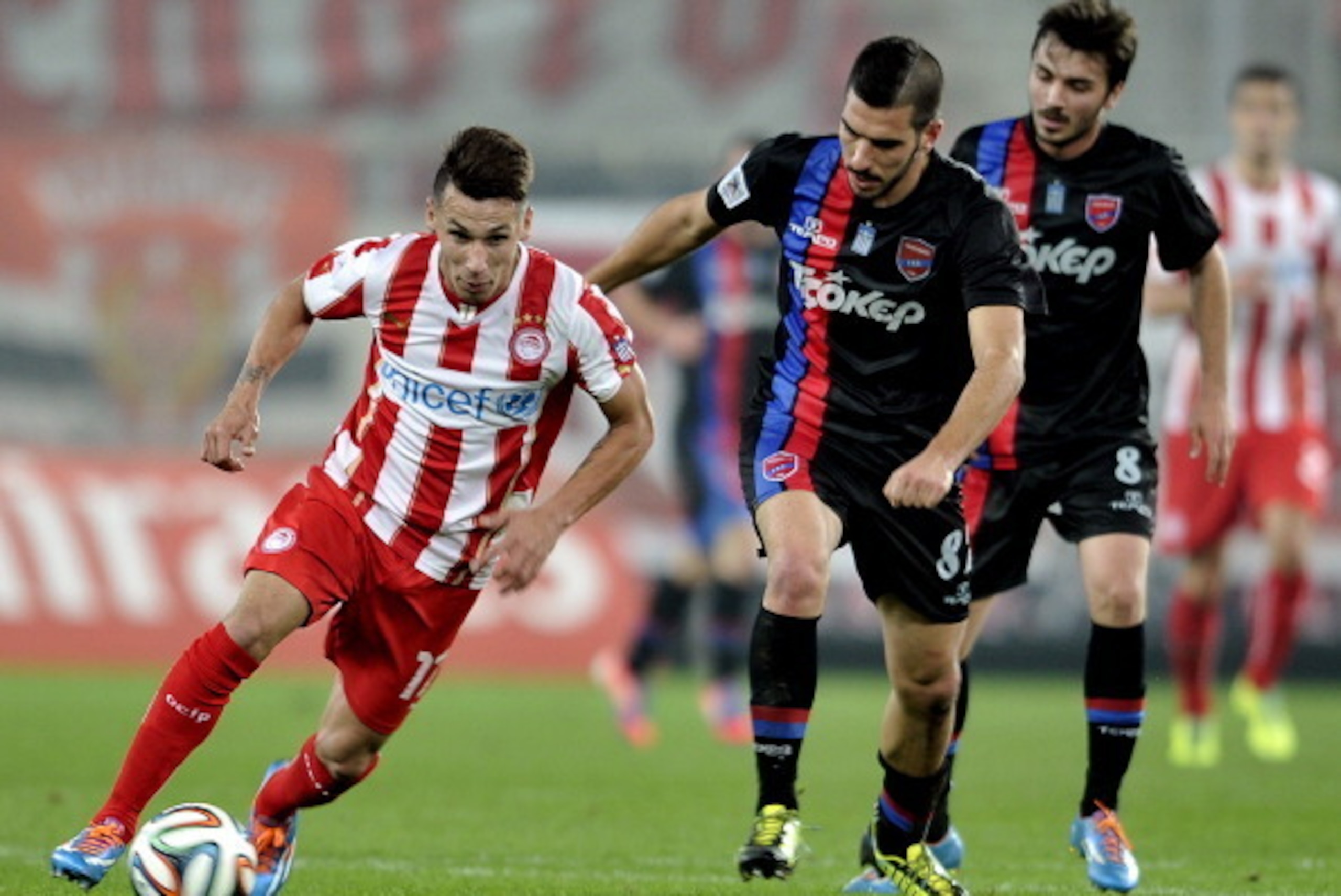 ATHENS,GREECE - FEBRUARY 5:  Hernan Perez of Olympiacos F.C. is followed by Pavlos Mitropoulos of Panionios GSS during the Greek Superleague  match between Olympiacos F.C. and Panionios GSS at the Karaiskaki Stadium on February  5, 2014 in Piraeus near At