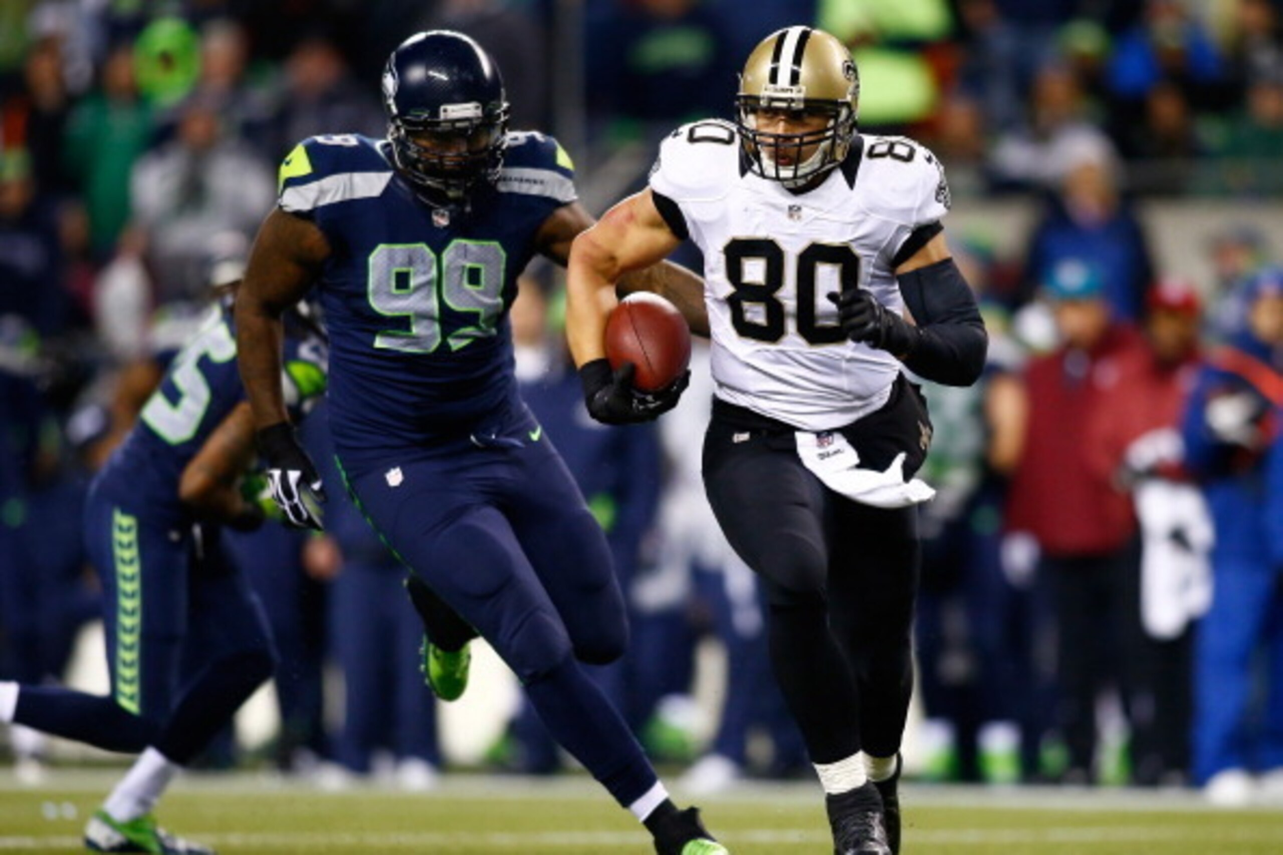 SEATTLE, WA - DECEMBER 02: Tight end Jimmy Graham #80 of the New Orleans Saints runs with the ball after a reception as defensive tackle Tony McDaniel #99 of the Seattle Seahawks defends during a game at CenturyLink Field on December 2, 2013 in Seattle, W