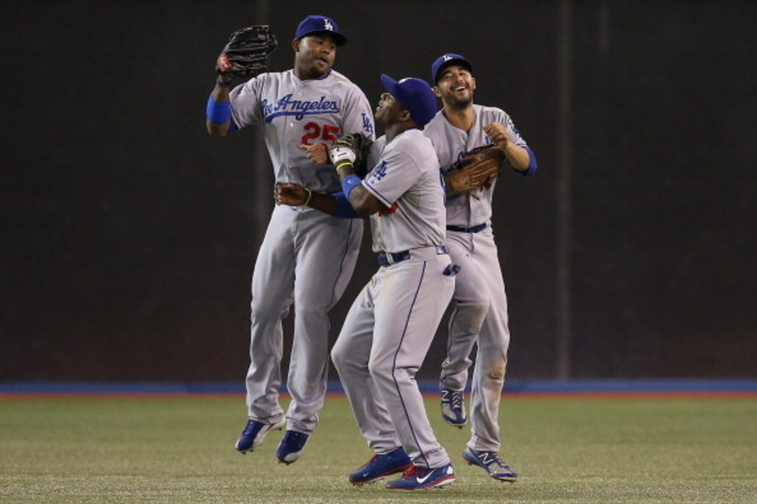 TORONTO, CANADA - JULY 23: Carl Crawford #25 of the Los Angeles Dodgers celebrates their victory with Yasiel Puig #66 and Andre Ethier #16 during MLB game action against the Toronto Blue Jays on July 23, 2013 at Rogers Centre in Toronto, Ontario, Canada. 