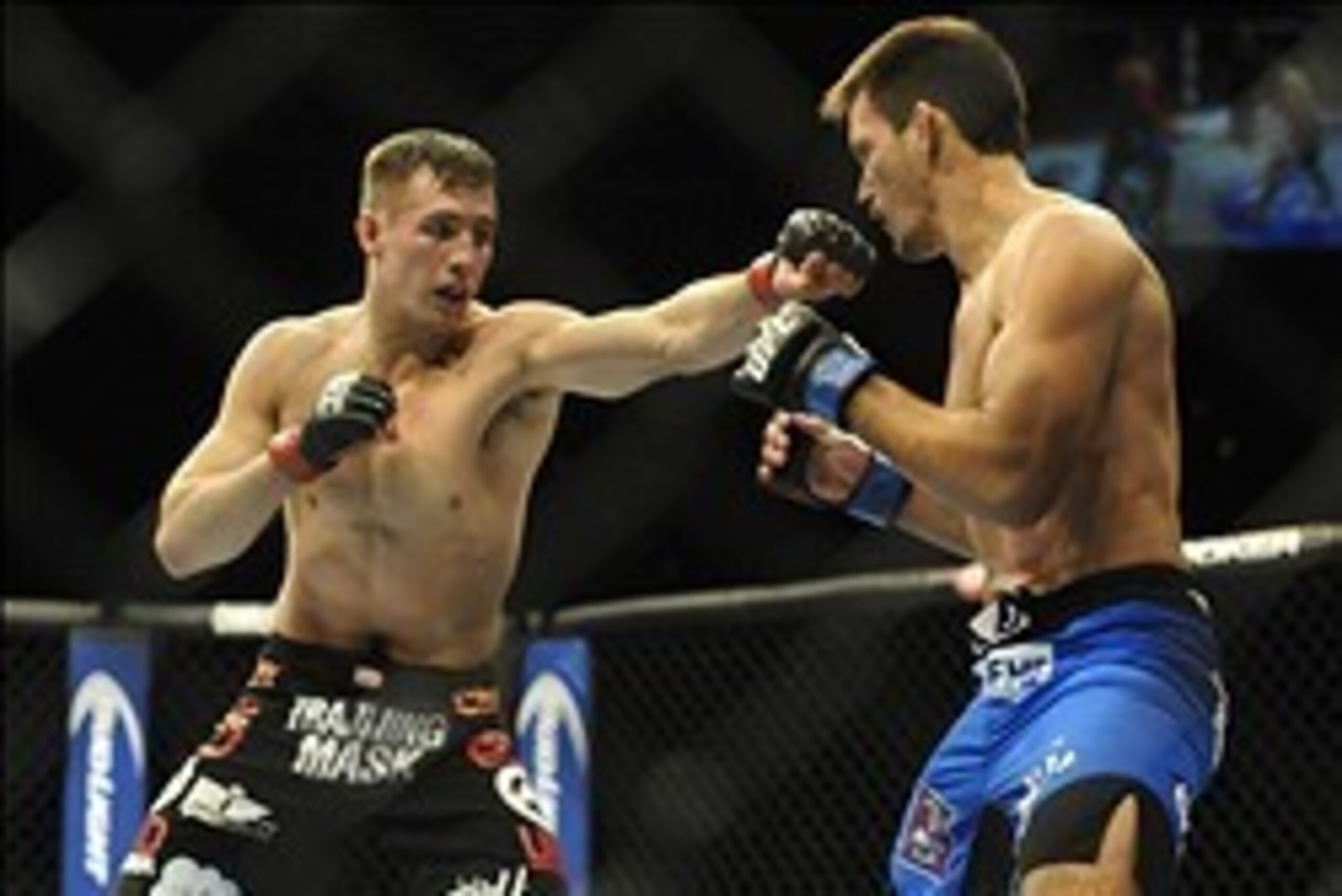 Feb 22, 2014; Las Vegas, NV, USA;  Rory MacDonald (red gloves) throws a punch at Demian Maia (blue gloves) during their UFC welterweight bout at Mandalay Bay. MacDonald won by way of a 29-28 decision. Mandatory Credit: Stephen R. Sylvanie-USA TODAY Sports