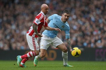 MANCHESTER, ENGLAND - FEBRUARY 22:  Aleksandar Kolarov of Manchester City in action with Stephen Ireland of Stoke City during the Barclays Premier League match between Manchester City and Stoke City at the Etihad Stadium on February 22, 2014 in Manchester