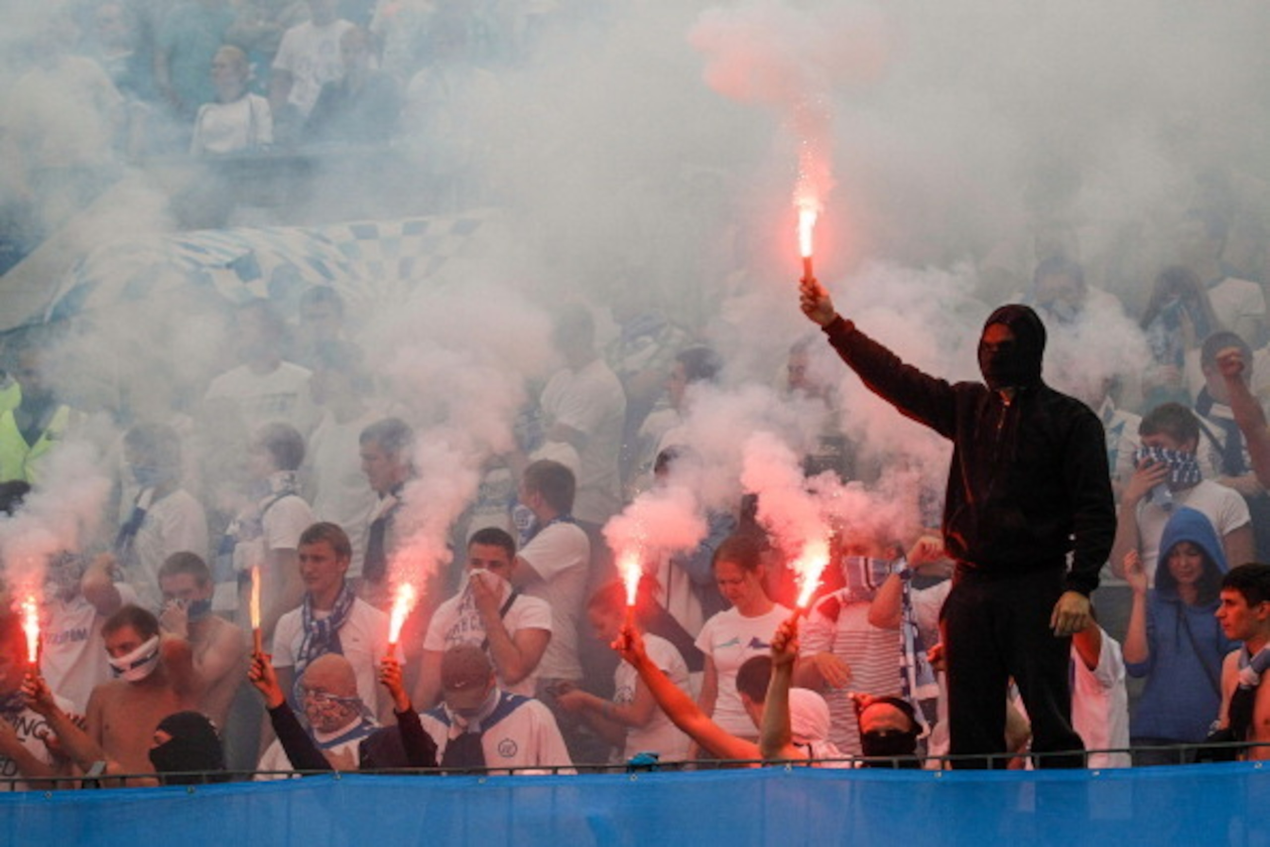 ST. PETERSBURG, RUSSIA - AUGUST 17: FC Zenit St. Petersburg supporters light flares during the Russian Premier League match between FC Zenit St. Petersburg and FC Anzhi Makhachkala at the Petrovsky stadium on August 17, 2013 in St. Petersburg, Russia. (Ph ST. PETERSBURG, RUSSIA - AUGUST 17: FC Zenit St. Petersburg supporters light flares during the Russian Premier League match between FC Zenit St. Petersburg and FC Anzhi Makhachkala at the Petrovsky stadium on August 17, 2013 in St. Petersburg, Russia. (Ph