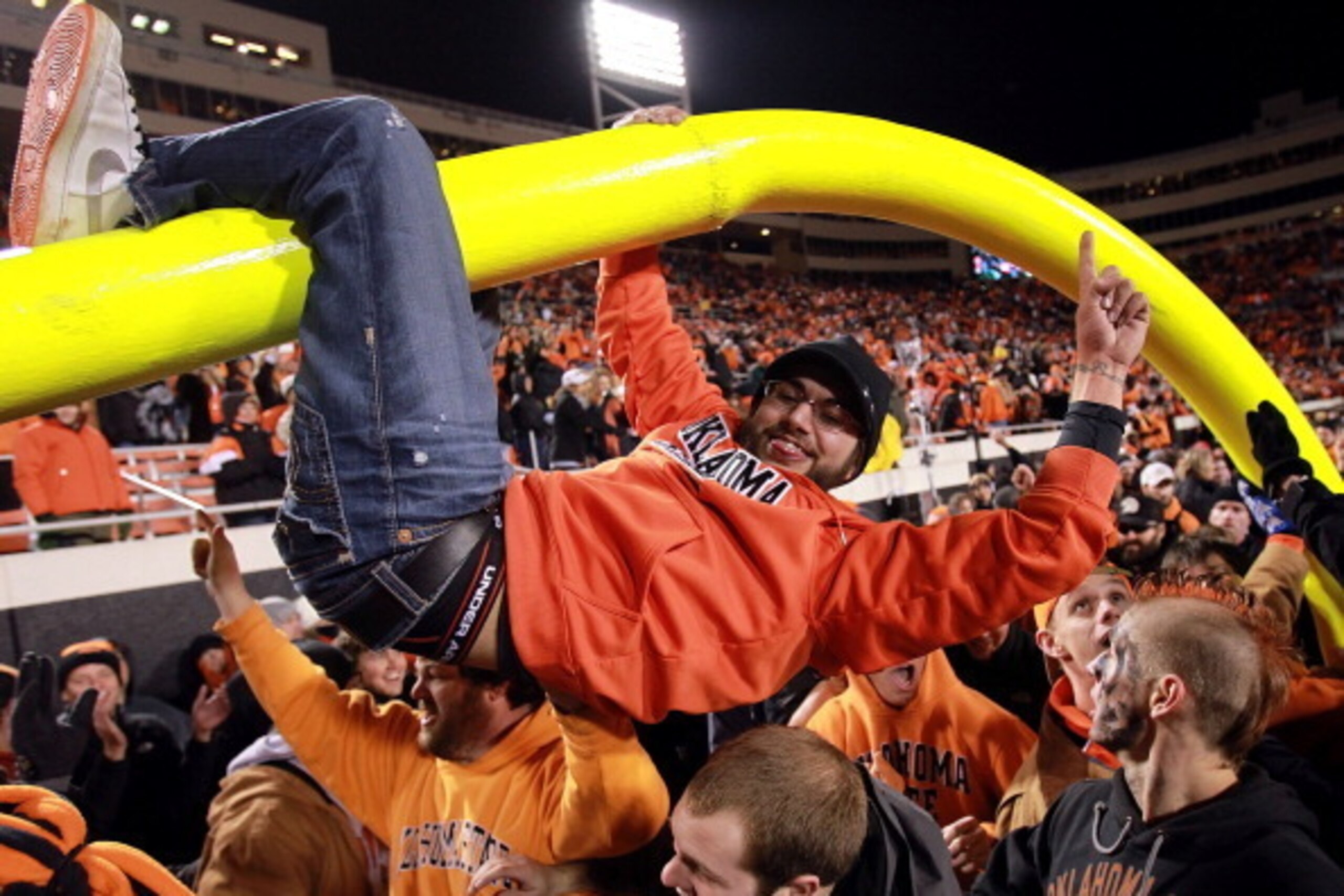 STILLWATER, OK - DECEMBER 03:  Oklahoma State Cowboys fans hang on the goal post after a 44-10 win against the Oklahoma Sooners at Boone Pickens Stadium on December 3, 2011 in Stillwater, Oklahoma.  (Photo by Ronald Martinez/Getty Images)