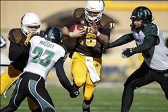 Nov 23, 2013; Laramie, WY, USA; Wyoming Cowboys quarterback Brett Smith (16) runs against Hawaii Warriors cornerback Dee Maggitt (23) and linebacker Brenden Daley (56) during the first quarter at War Memorial Stadium. The Cowboys defeated the Warriors 59-