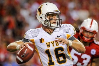 LINCOLN, NE - AUGUST 31: Quarterback Brett Smith #16 of the Wyoming Cowboys scrambles away from defensive tackle Thad Randle #53 of the Nebraska Cornhuskers during their game at Memorial Stadium on August 31, 2013 in Lincoln, Nebraska. Nebraska defeated W