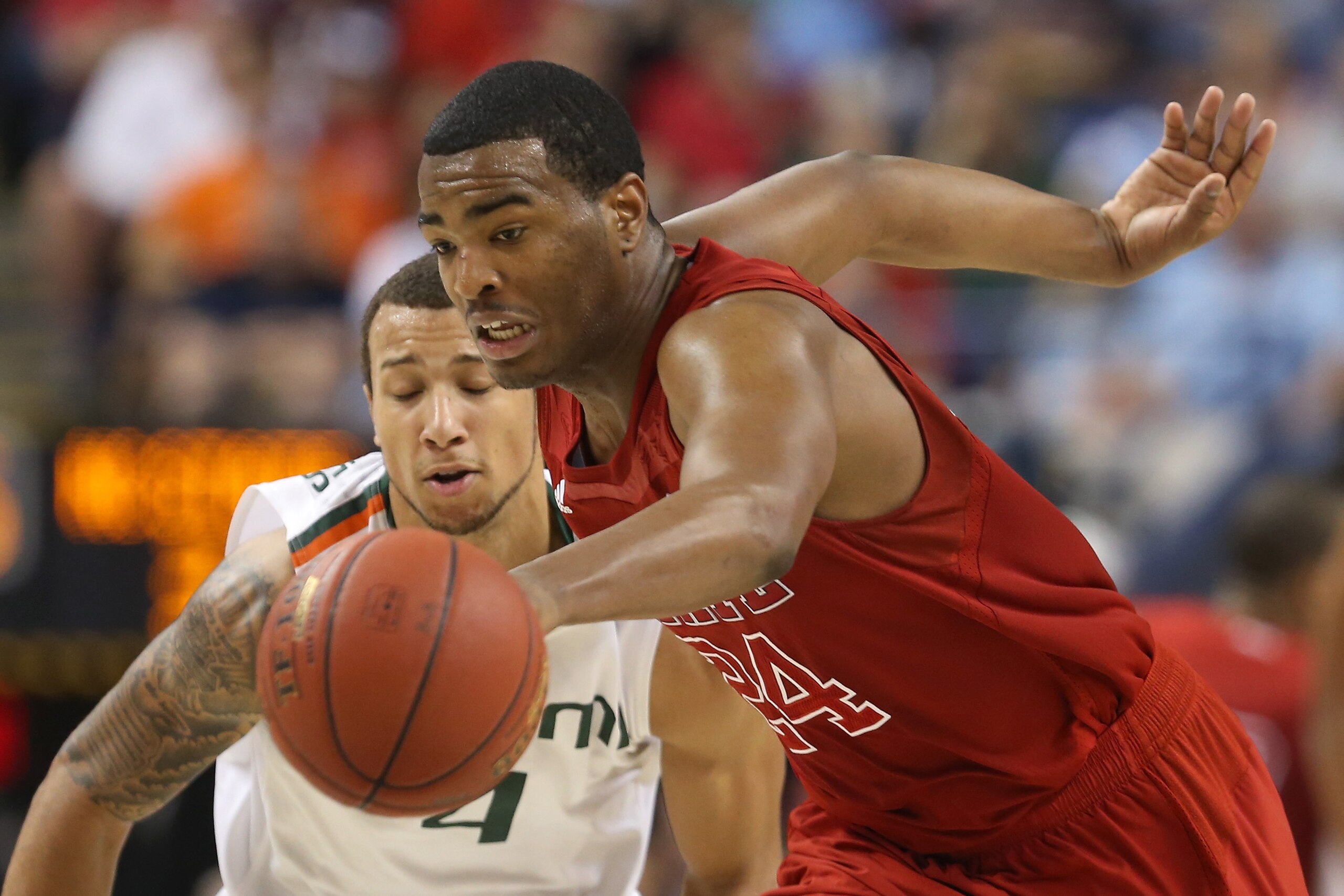 GREENSBORO, NC - MARCH 16:  T.J. Warren #24 of the North Carolina State Wolfpack moves the ball in front of Trey McKinney Jones #4 of the Miami Hurricanes in the second half during the men's ACC Tournament semifinals at Greensboro Coliseum on March 16, 20