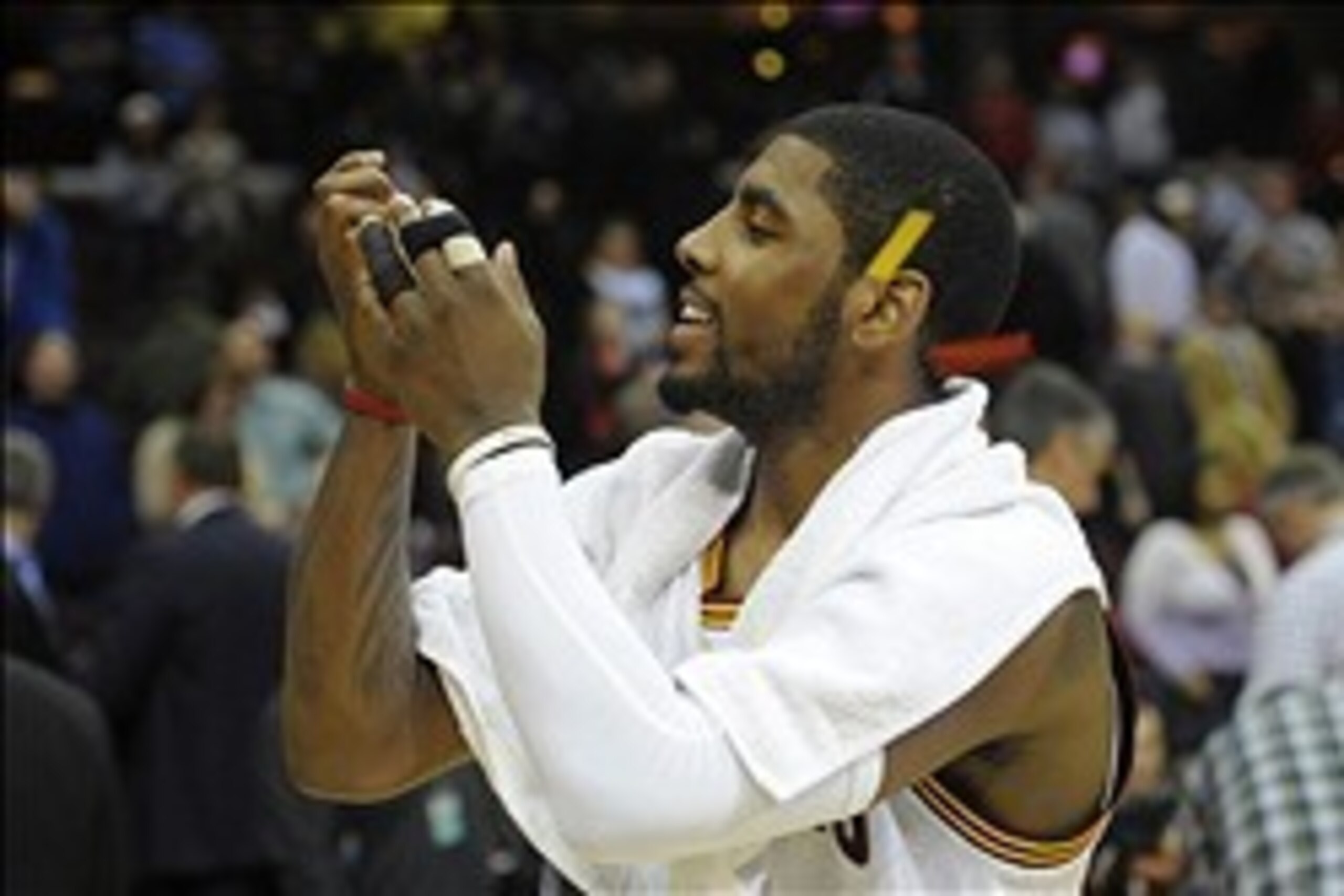 Feb 19, 2014; Cleveland, OH, USA; Cleveland Cavaliers point guard Kyrie Irving (2) catches a piece of confetti after a 101-93 win over the Orlando Magic at Quicken Loans Arena. Mandatory Credit: David Richard-USA TODAY Sports