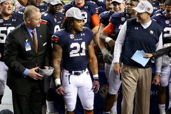ATLANTA, GA - DECEMBER 07:  Head coach Gus Malzahn of the Auburn Tigers congratulates Tre Mason #21 of the Auburn Tigers for being named MVP during the SEC Championship Game  at the  Georgia Dome on December 7, 2013 in Atlanta, Georgia.  (Photo by Mike Eh