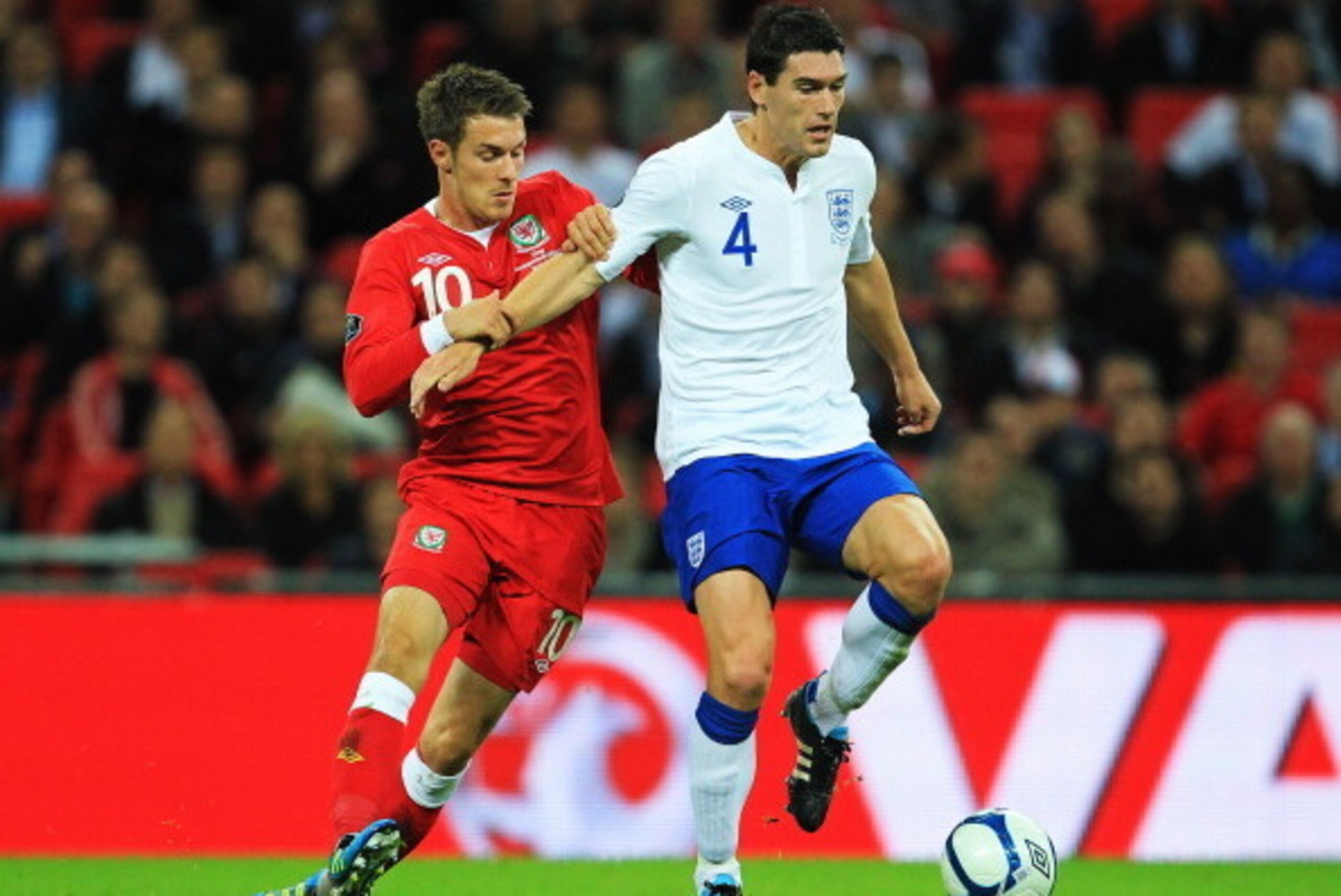 LONDON, ENGLAND - SEPTEMBER 06:  Aaron Ramsey (L) of Wales challenges Gareth Barry (R) of England during the UEFA EURO 2012 group G qualifying match between England and Wales at Wembley Stadium  on September 6, 2011 in London, England.  (Photo by David Ca