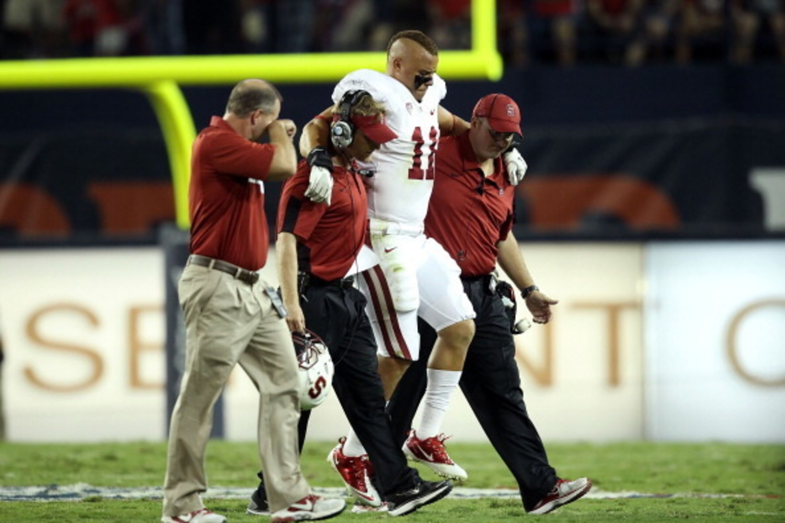 TUCSON, AZ - SEPTEMBER 17:  Linebacker Shayne Skov #11 of the Stanford Cardinal is helped off the field after an injury during the college football game against the Arizona Wildcats at Arizona Stadium on September 17, 2011 in Tucson, Arizona. The Cardinal