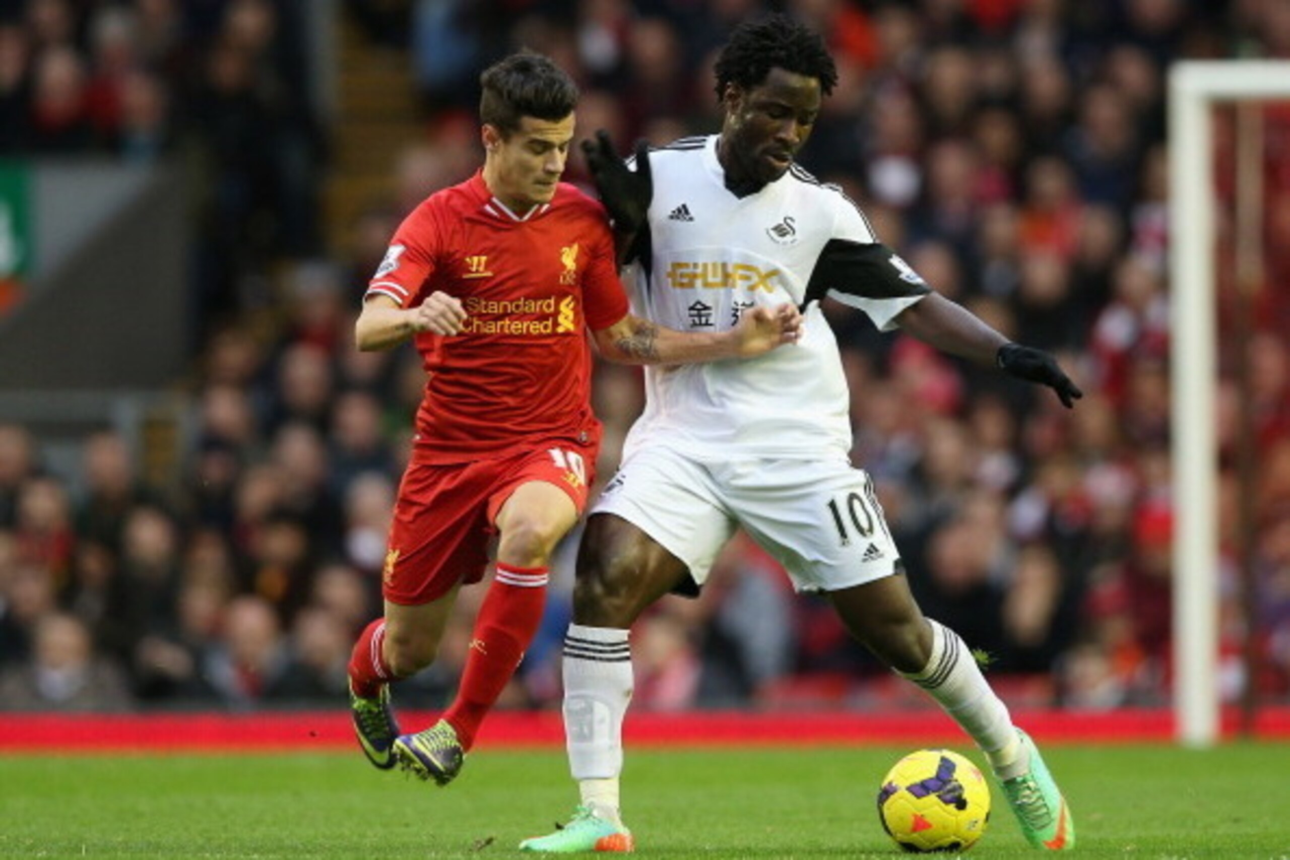 LIVERPOOL, ENGLAND - FEBRUARY 23:  Philippe Coutinho of Liverpool competes with Wilfried Bony of Swansea City during the Barclays Premier League match between Liverpool and Swansea City at Anfield on February 23, 2014 in Liverpool, England.  (Photo by Cli