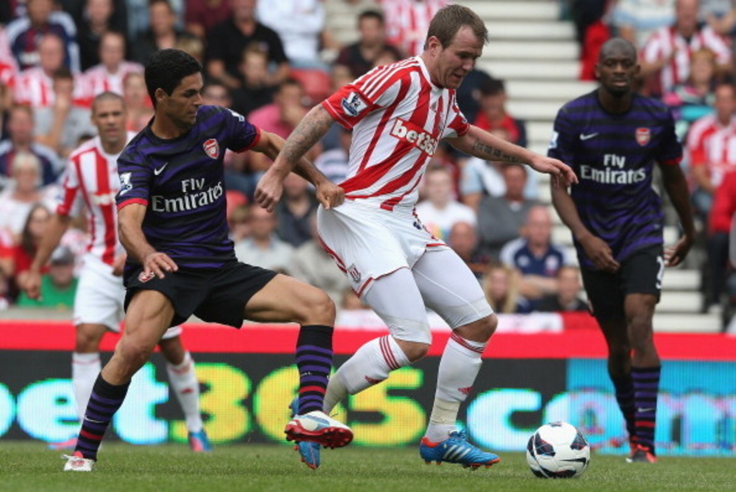 STOKE ON TRENT, ENGLAND - AUGUST 26:  Glenn Whelan of Stoke City is challenged by MIkel Arteta (L) during the Barclays Premier League match between Stoke City and Arsenal at the Britannia Stadium on August 26, 2012 in Stoke on Trent, England.  (Photo by D