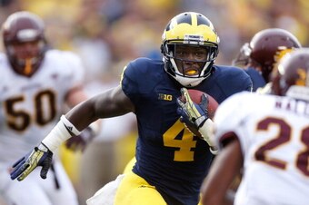 ANN ARBOR, MI - AUGUST 31: De'Veon Smith #4 of the Michigan Wolverines looks for extra yards during a fourth quarter run while playing the Central Michigan Chippewas at Michigan Stadium on August 31, 2013 in Ann Arbor, Michigan. Michigan won the 59-9. (Ph