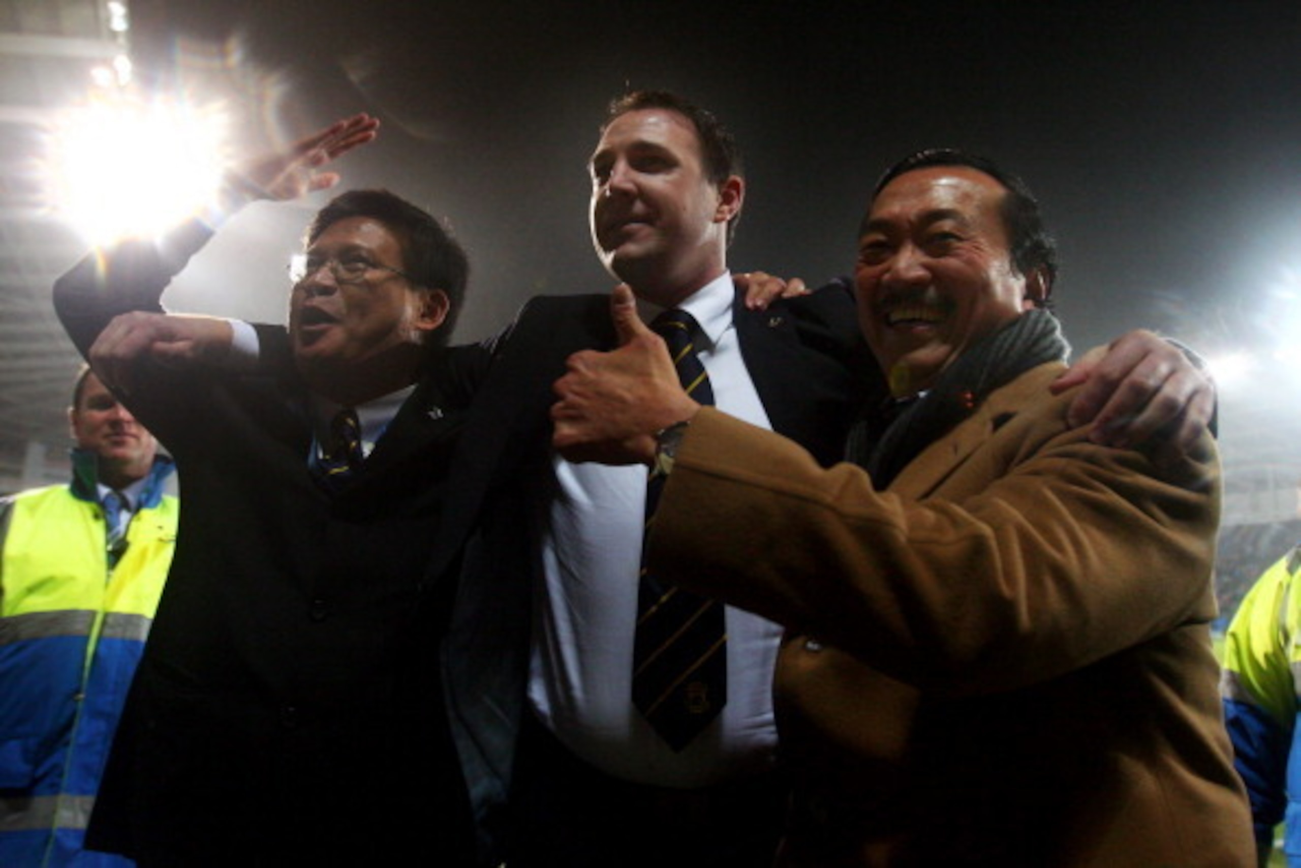 CARDIFF, WALES - JANUARY 24:  Malky Mackay the Cardiff City manager celebrates with club owner Tan Sri Vincent Tan Chee Yioun (right) and chairman Chan Tien Ghee (left) following his team's 3-1 victory in the penalty shootout during the Carling Cup Semi F