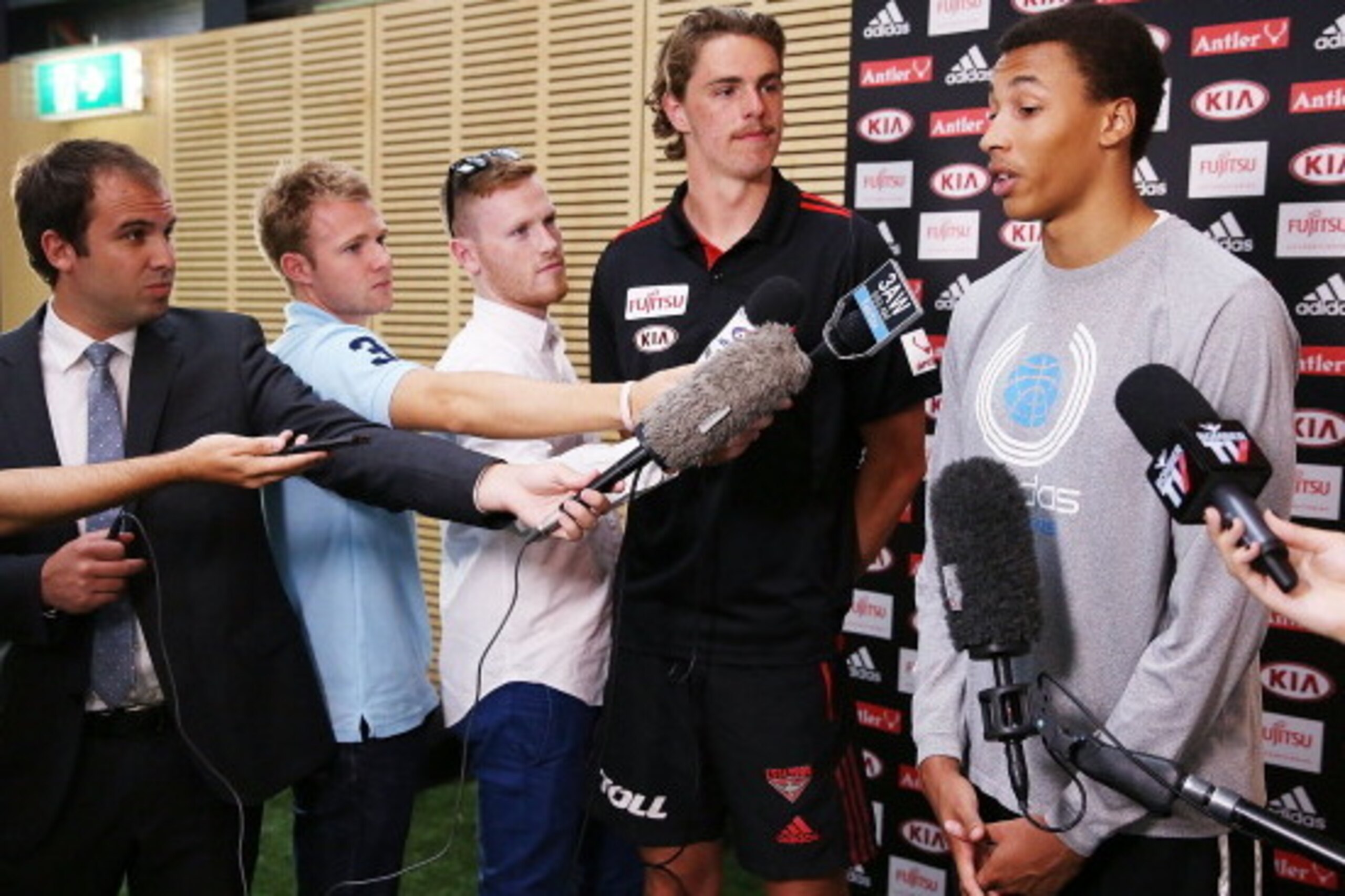 MELBOURNE, AUSTRALIA - FEBRUARY 14:  Young Australian basketball player Dante Exum (R) and Joe Daniher of the Bombers  speak during an Essendon Bombers AFL media session at True Value Solar Centre on February 14, 2014 in Melbourne, Australia.  (Photo by M