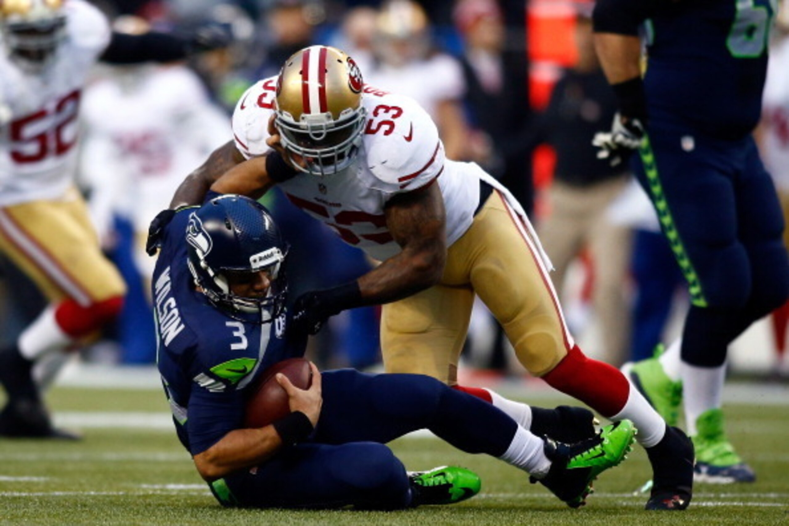 SEATTLE, WA - JANUARY 19:  Quarterback Russell Wilson #3 of the Seattle Seahawks is hit by inside linebacker NaVorro Bowman #53 of the San Francisco 49ers in the first half during the 2014 NFC Championship at CenturyLink Field on January 19, 2014 in Seatt