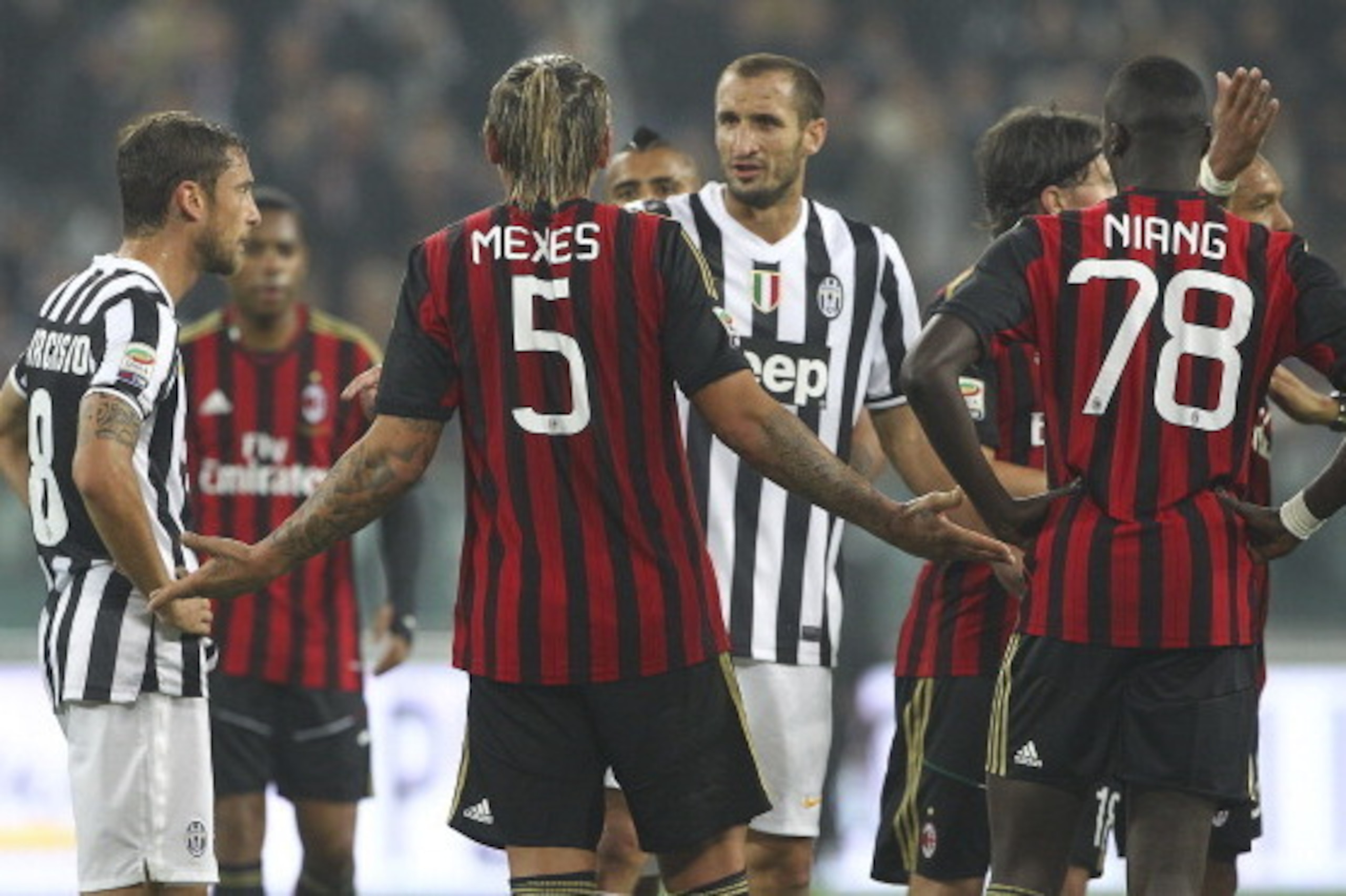 TURIN, ITALY - OCTOBER 06:  Philippe Mexes #5 of AC Milan disputes with Giorgio Chiellini of Juventus FC after getting a red card during the Serie A match between Juventus and AC Milan at Juventus Arena on October 6, 2013 in Turin, Italy.  (Photo by Marco