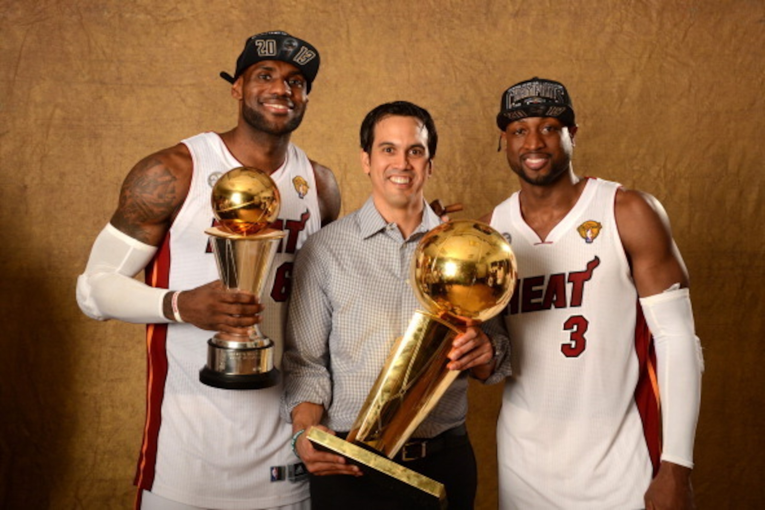 MIAMI, FL - JUNE 20: LeBron James #6, Head Coach Erik Spoelstra and Dwyane Wade #3 of the Miami Heat poses for a portrait with the Larry O'Brien Trophy after defeating the San Antonio Spurs in Game Seven of the 2013 NBA Finals on June 20, 2013 at American