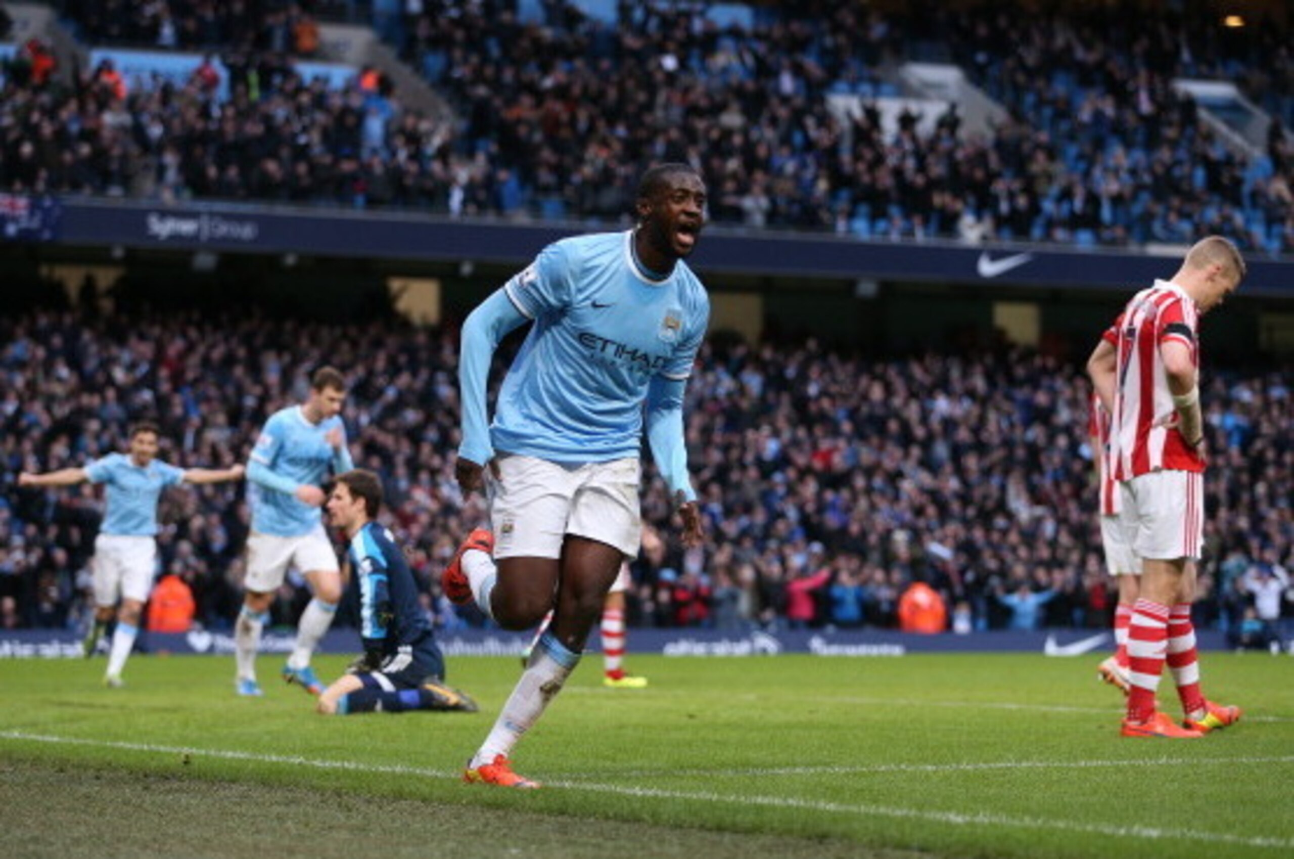 MANCHESTER, ENGLAND - FEBRUARY 22:  Yaya Toure of Manchester City runs away to celebrate after scoring the winning goal during the Barclays Premier League match between Manchester City and Stoke City at the Etihad Stadium on February 22, 2014 in Mancheste