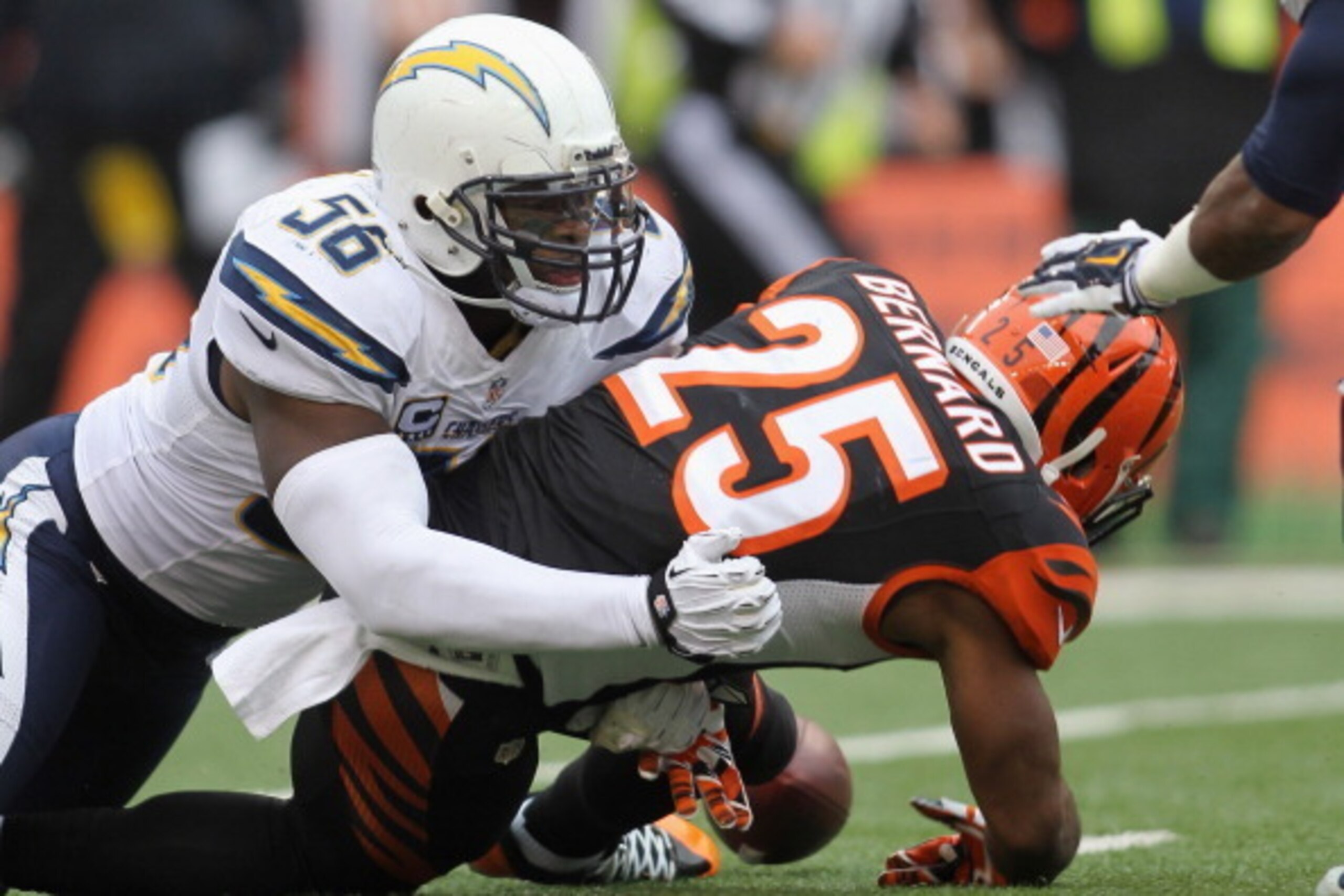 CINCINNATI, OH - JANUARY 05:  Giovani Bernard #25 of the Cincinnati Bengals fumbles the football after being hit by Donald Butler #56 of the San Diego Chargers during their AFC Wild Card playoff game at Paul Brown Stadium on January 5, 2014 in Cincinnati,