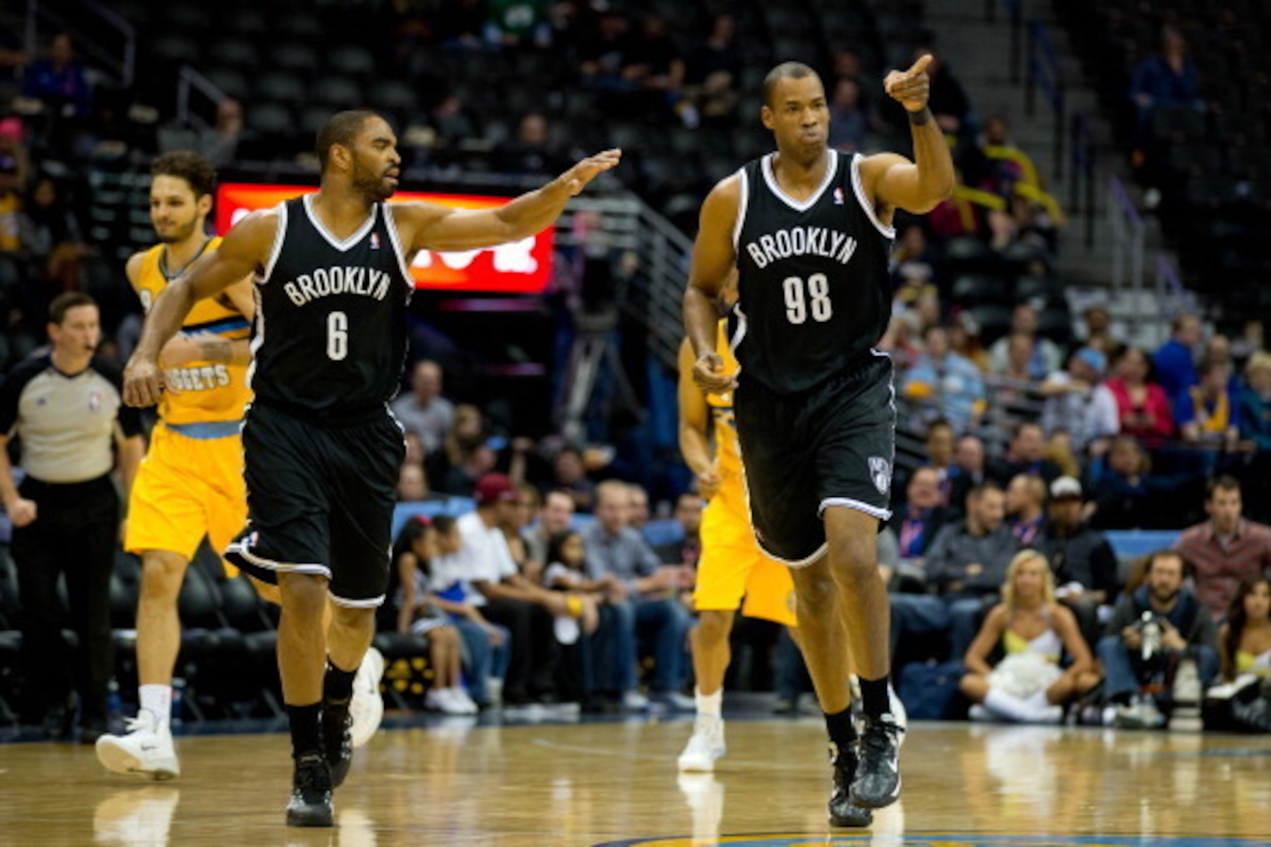 DENVER, CO - FEBRUARY 27:  Jason Collins #98 of the Brooklyn Nets celebrates after making a basket with teammate Alan Anderson #6 during a game against the Denver Nuggets at Pepsi Center on February 27, 2014 in Denver, Colorado. Collins is the first openl