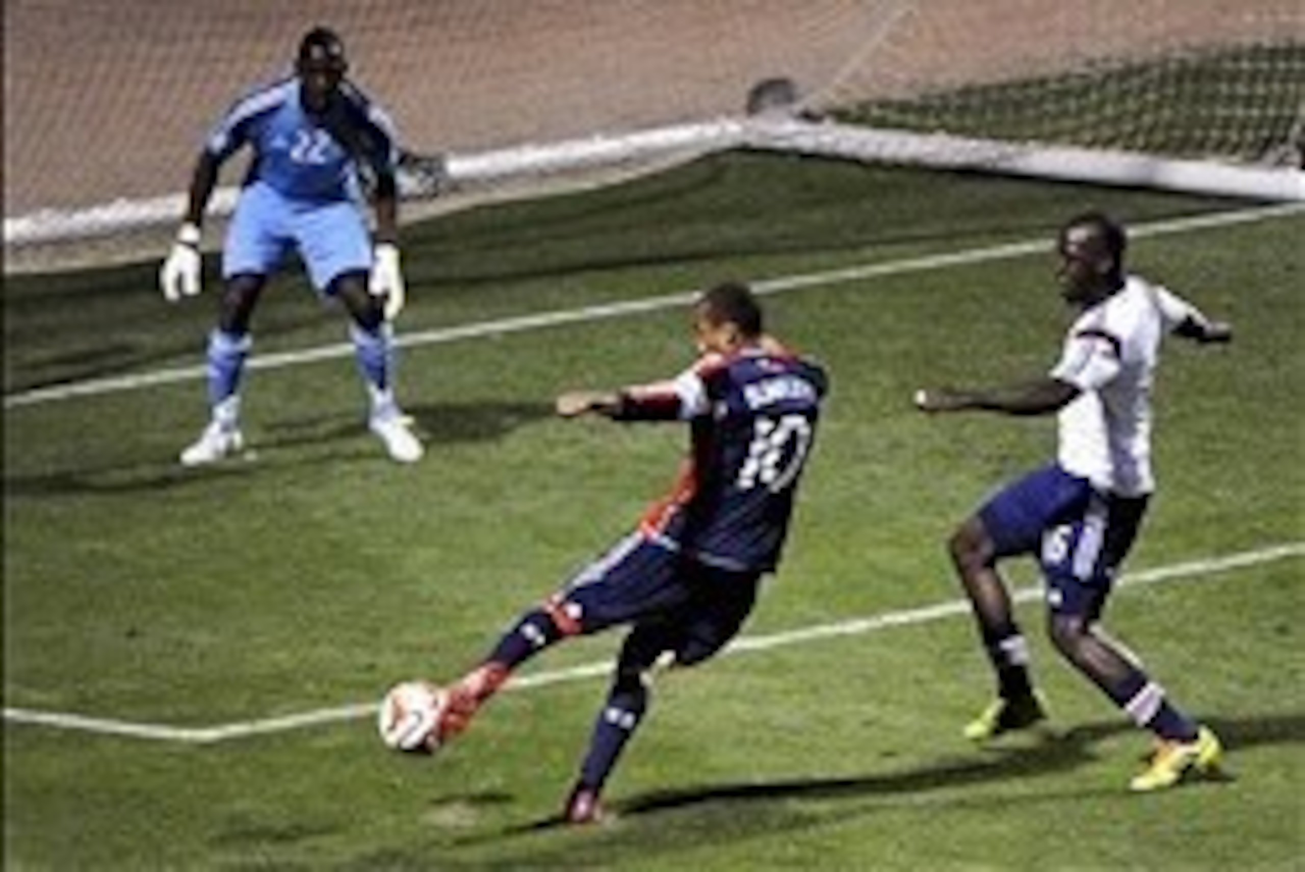 Feb 22, 2014; Tucson, AZ, USA; New England Revolution forward Teal Bunbury (10) scores on goal as Chivas USA goalkeeper Larry Jackson (22) defends during the first half at Kino Sports Complex. Mandatory Credit: Casey Sapio-USA TODAY Sports