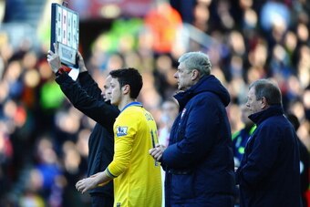 STOKE ON TRENT, ENGLAND - MARCH 01:  Arsene Wenger of Arsenal bring on substitute Mesut Ozil during the Barclays Premier League match between Stoke City and Arsenal at Britannia Stadium on March 1, 2014 in Stoke on Trent, England.  (Photo by Laurence Grif
