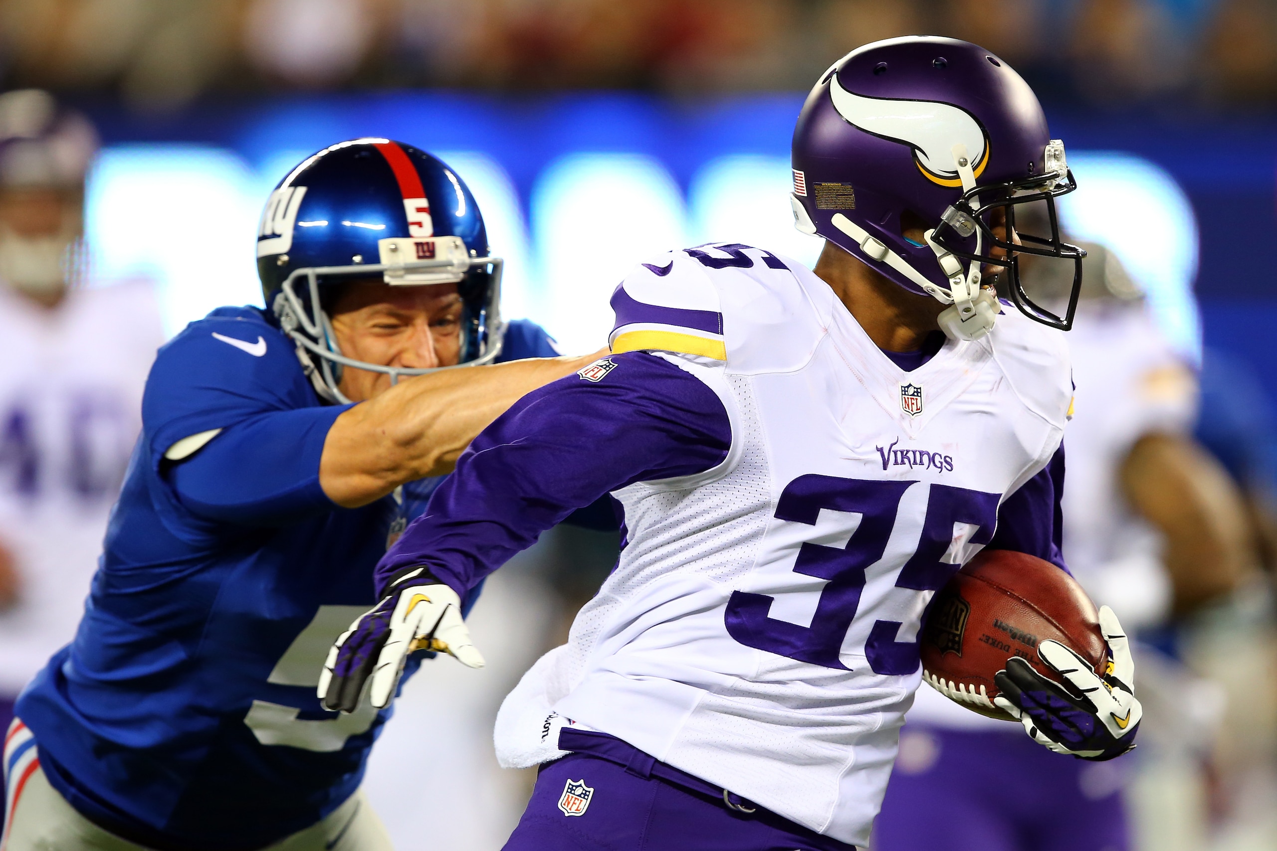 EAST RUTHERFORD, NJ - OCTOBER 21:  Cornerback Marcus Sherels #35 of the Minnesota Vikings returns a punt for a touchdown in the first quarter as punter Steve Weatherford #5 of the New York Giants tries to make the tackle during a game at MetLife Stadium o