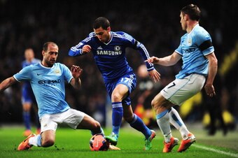 MANCHESTER, ENGLAND - FEBRUARY 15:  Eden Hazard (C) of Chelsea holds off the challenge of Pablo Zabaleta (L) and James Milner (R) of Manchester City during the FA Cup Fifth Round match between Manchester City and Chelsea at the Etihad Stadium on February 