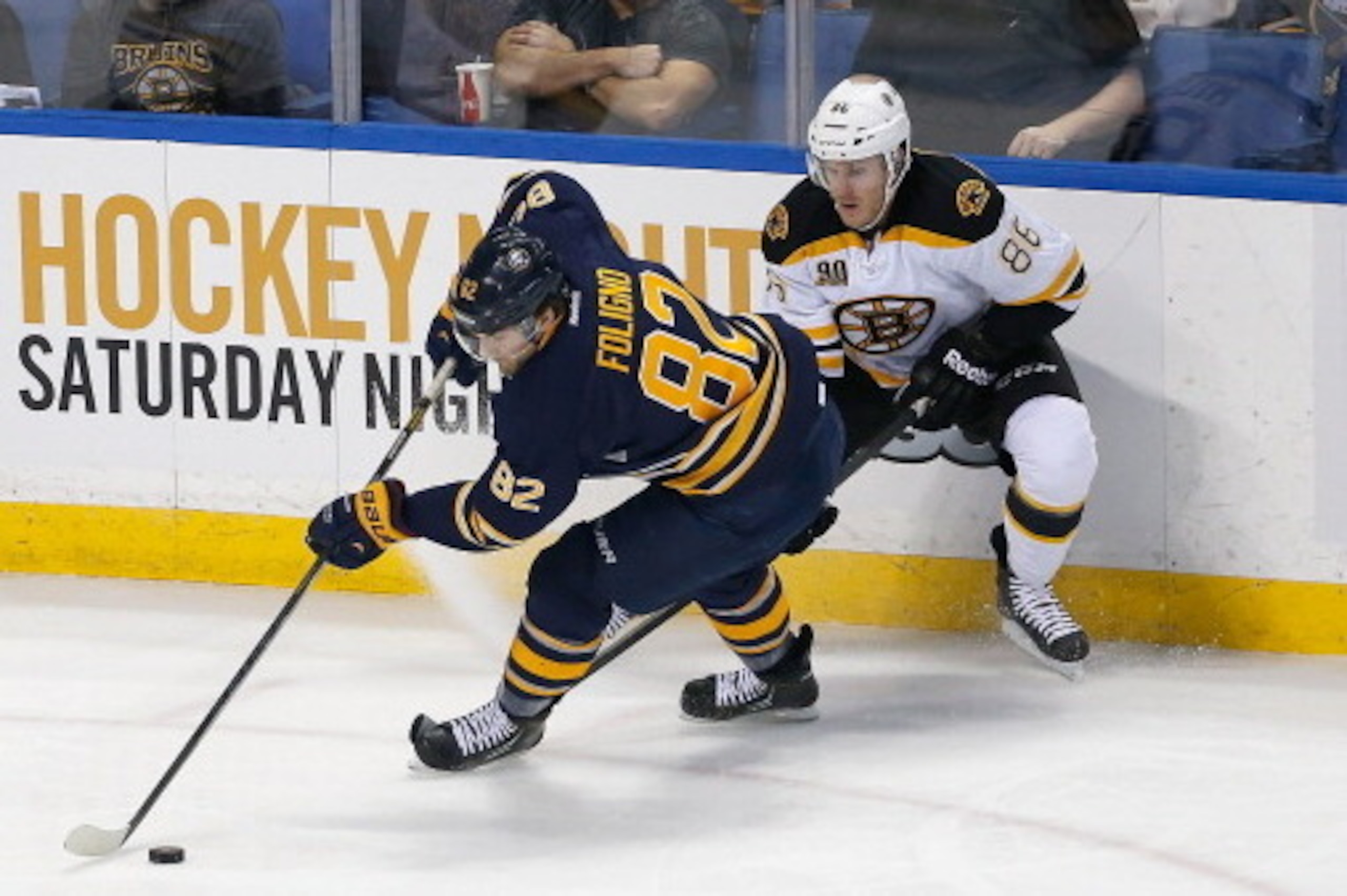 BUFFALO, NY - FEBRUARY 26:  Marcus Foligno #82 of the Buffalo Sabres works to move the puck out of his zone against Kevan Miller #86 of the Boston Bruins at First Niagara Center on February 26, 2014 in Buffalo, New York.  (Photo by Rick Stewart/Getty Imag