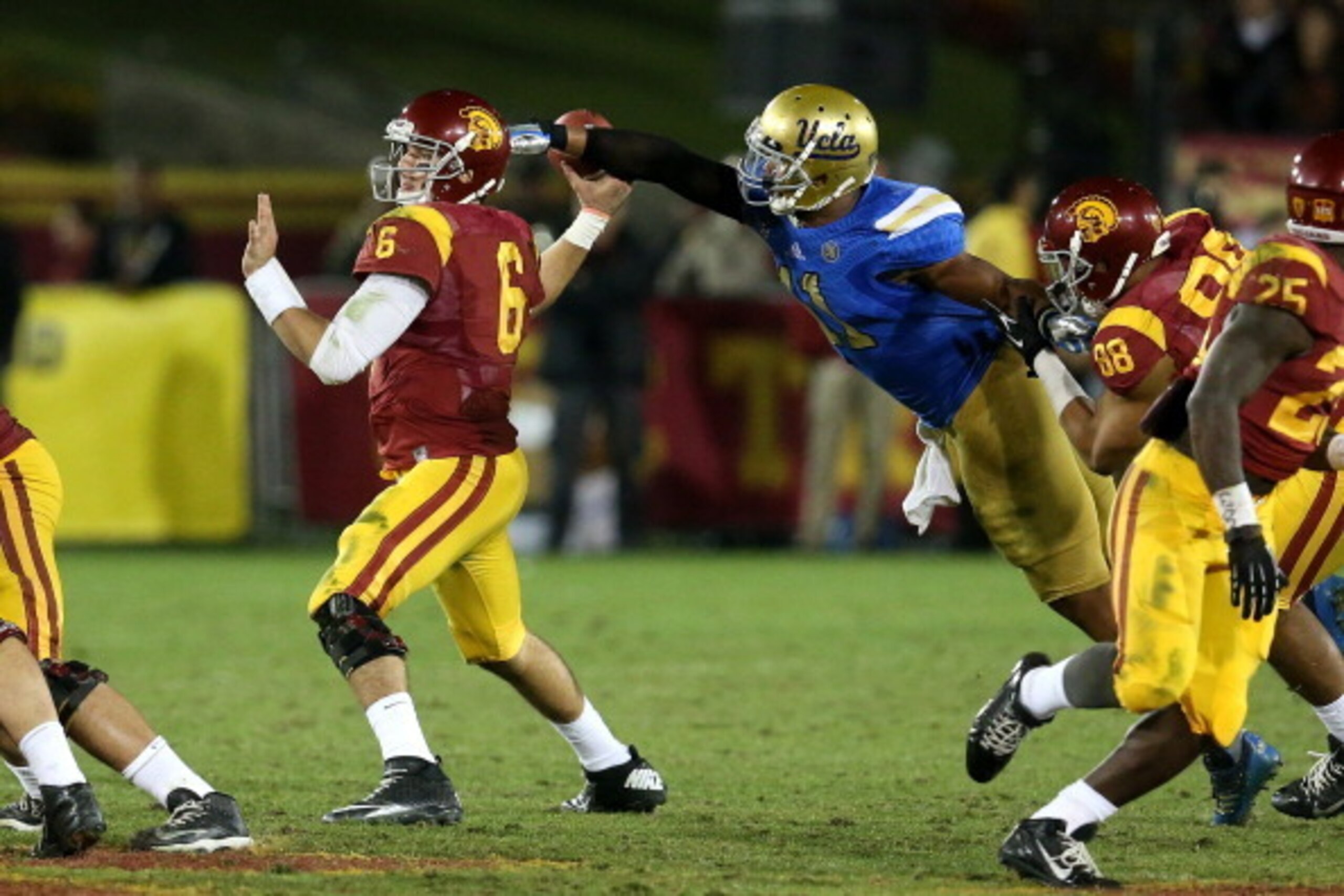 LOS ANGELES, CA - NOVEMBER 30:  Linebacker Anthony Barr #11 of the UCLA Bruins strips the ball  from quarterback Cody Kessler #36 of the USC Trojans for a fumble and a turnover in the fourth quarter at Los Angeles Coliseum on November 30, 2013 in Los Ange