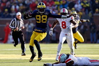 ANN ARBOR, MI - NOVEMBER 30: Quarterback Devin Gardner #98 of the Michigan Wolverines avoids a tackle by cornerback Bradley Roby #1 of the Ohio State Buckeyes during a game at Michigan Stadium on November 30, 2013 in Ann Arbor, Michigan.  (Photo by Gregor