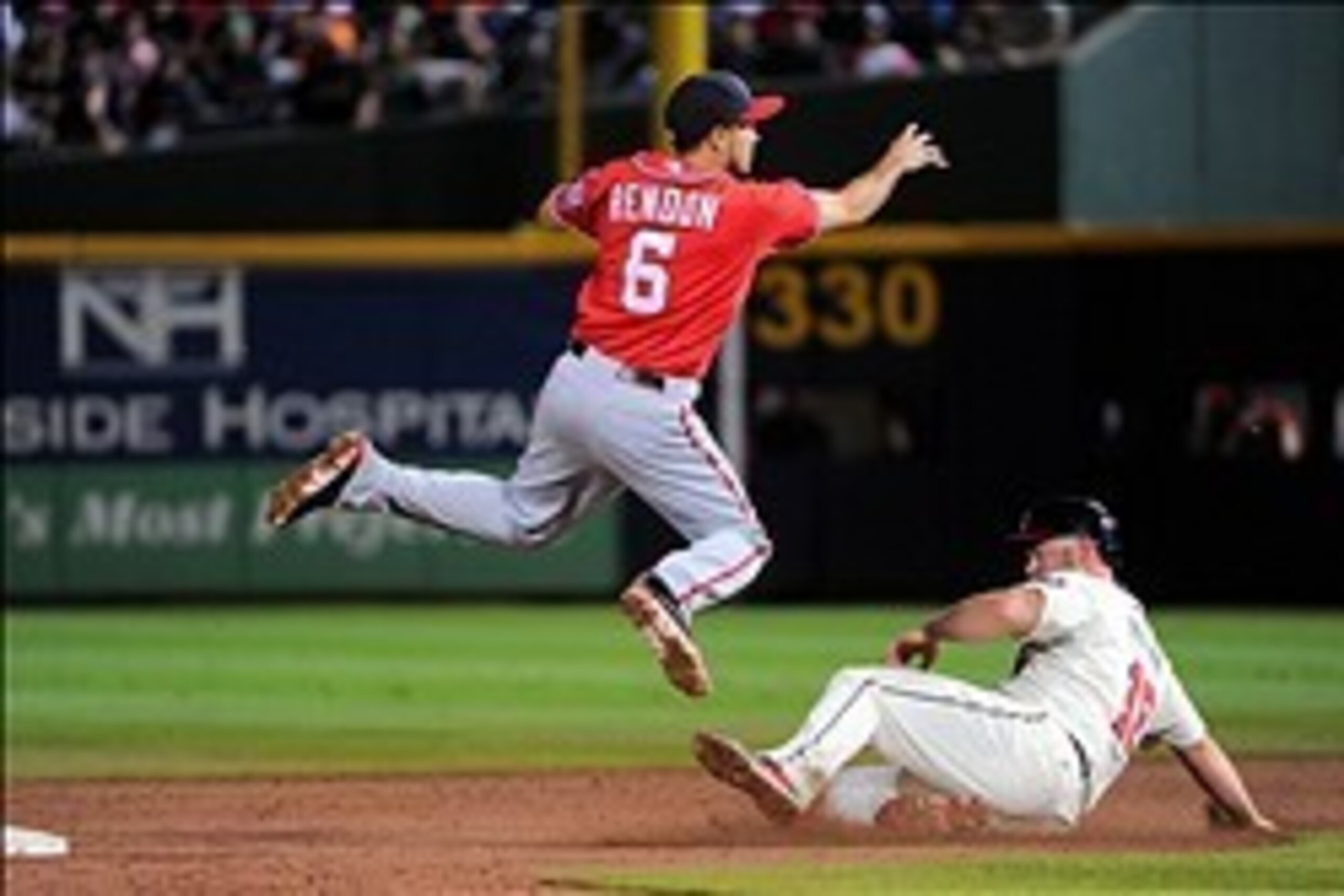 Aug 17, 2013; Atlanta, GA, USA; Washington Nationals second baseman Anthony Rendon (6) turns a double play over top of Atlanta Braves catcher Brian McCann (16) during the third inning at Turner Field. Mandatory Credit: Dale Zanine-USA TODAY Sports