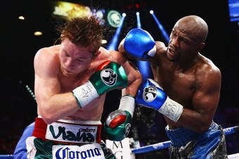 LAS VEGAS, NV - SEPTEMBER 14:  (L-R) Floyd Mayweather Jr. throws a right to Canelo Alvarez during their WBC/WBA 154-pound title fight at the MGM Grand Garden Arena on September 14, 2013 in Las Vegas, Nevada.  (Photo by Al Bello/Getty Images)