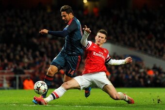 LONDON, ENGLAND - FEBRUARY 19:  Laurent Koscielny of Arsenal tackles Claudio Pizarro of Bayern Muenchen during the UEFA Champions League Round of 16 first leg match between Arsenal and FC Bayern Muenchen at Emirates Stadium on February 19, 2014 in London,