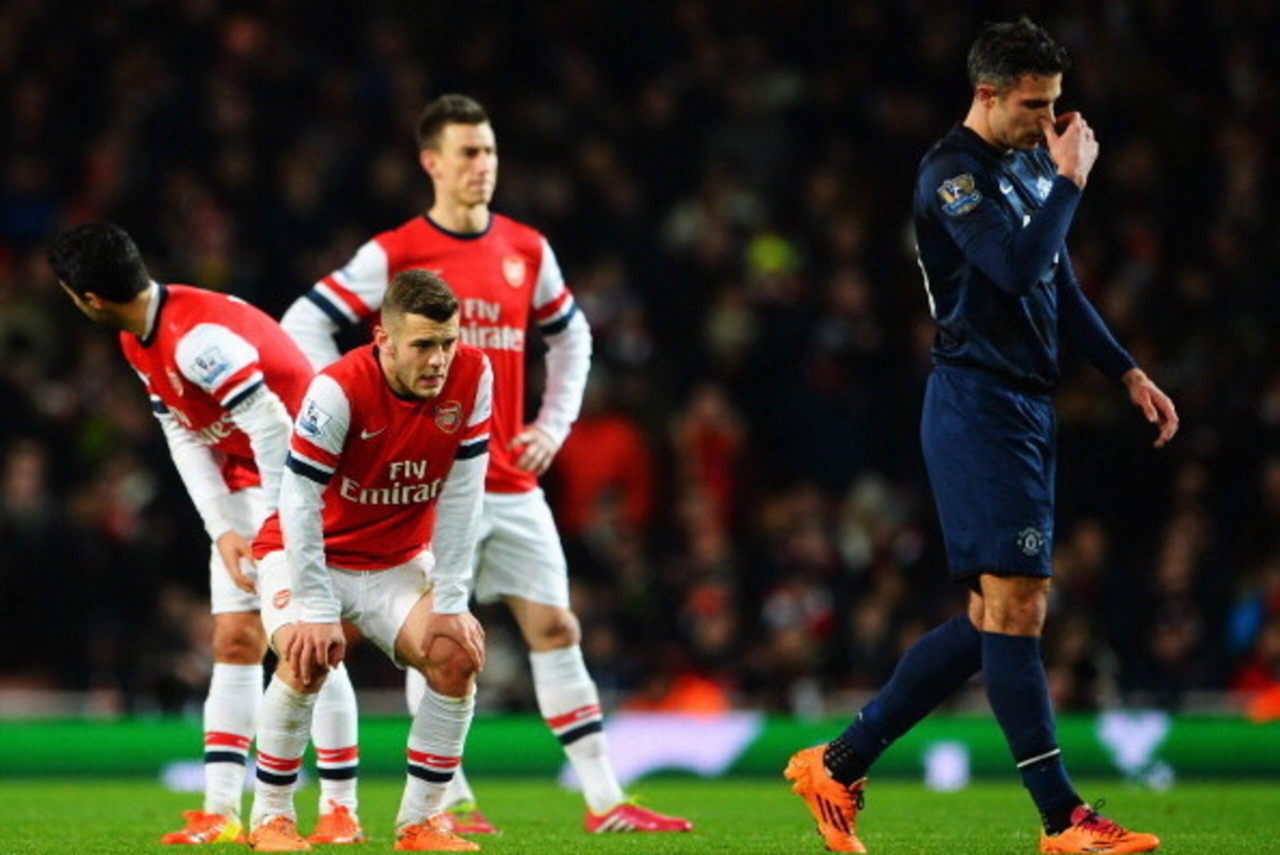 LONDON, ENGLAND - FEBRUARY 12:  Jack Wilshere (L) of Arsenal and Robin van Persie (R) of Manchester United react during the Barclays Premier League match between Arsenal and Manchester United at the Emirates Stadium on February 12, 2014 in London, England