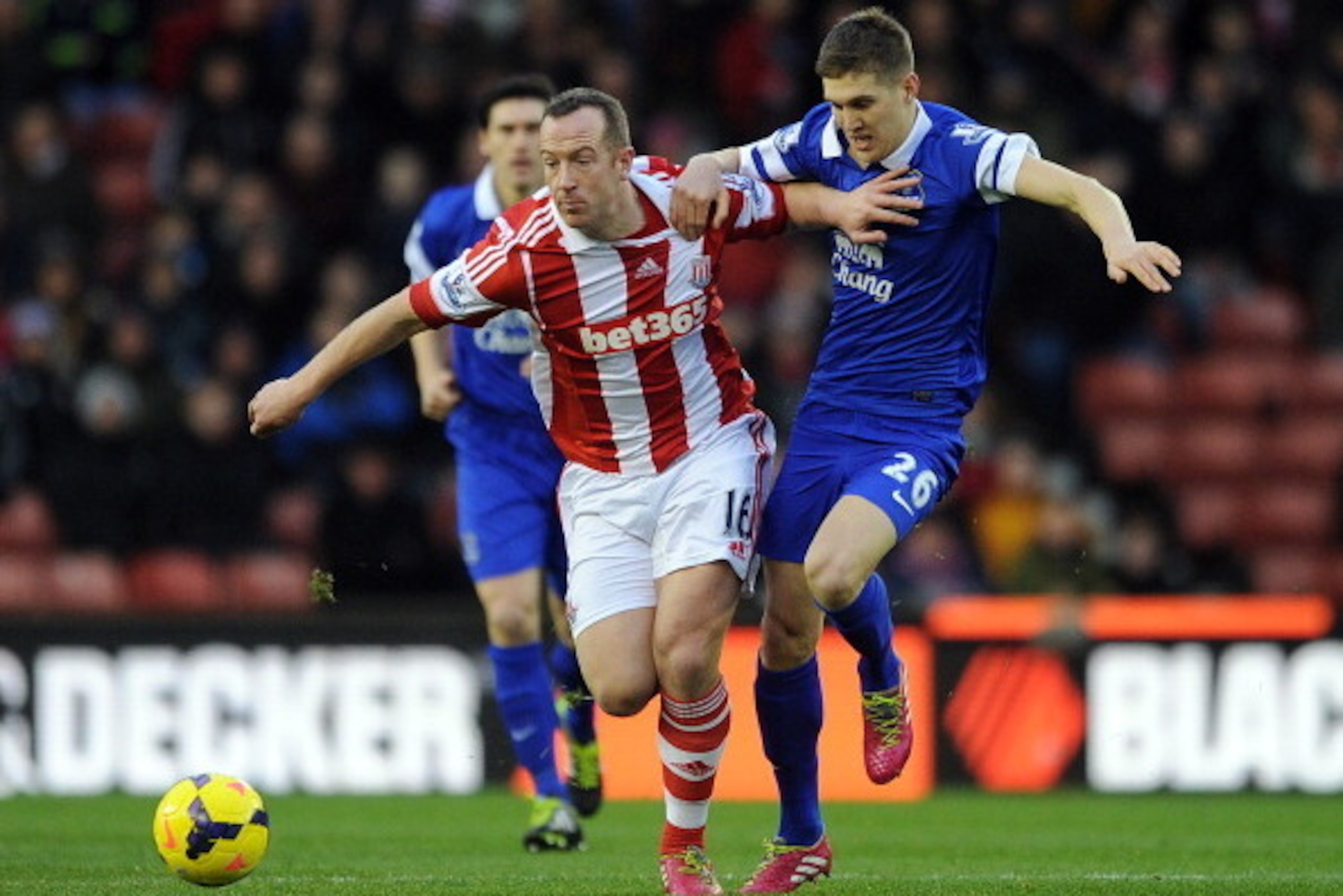 STOKE ON TRENT, ENGLAND - JANUARY 01: Charlie Adam of Stoke City competes with John Stones of Everton during the Barclays Premier League match between Stoke City and Everton at Britannia Stadium on January 01, 2014 in Stoke on Trent, England. (Photo by Ch