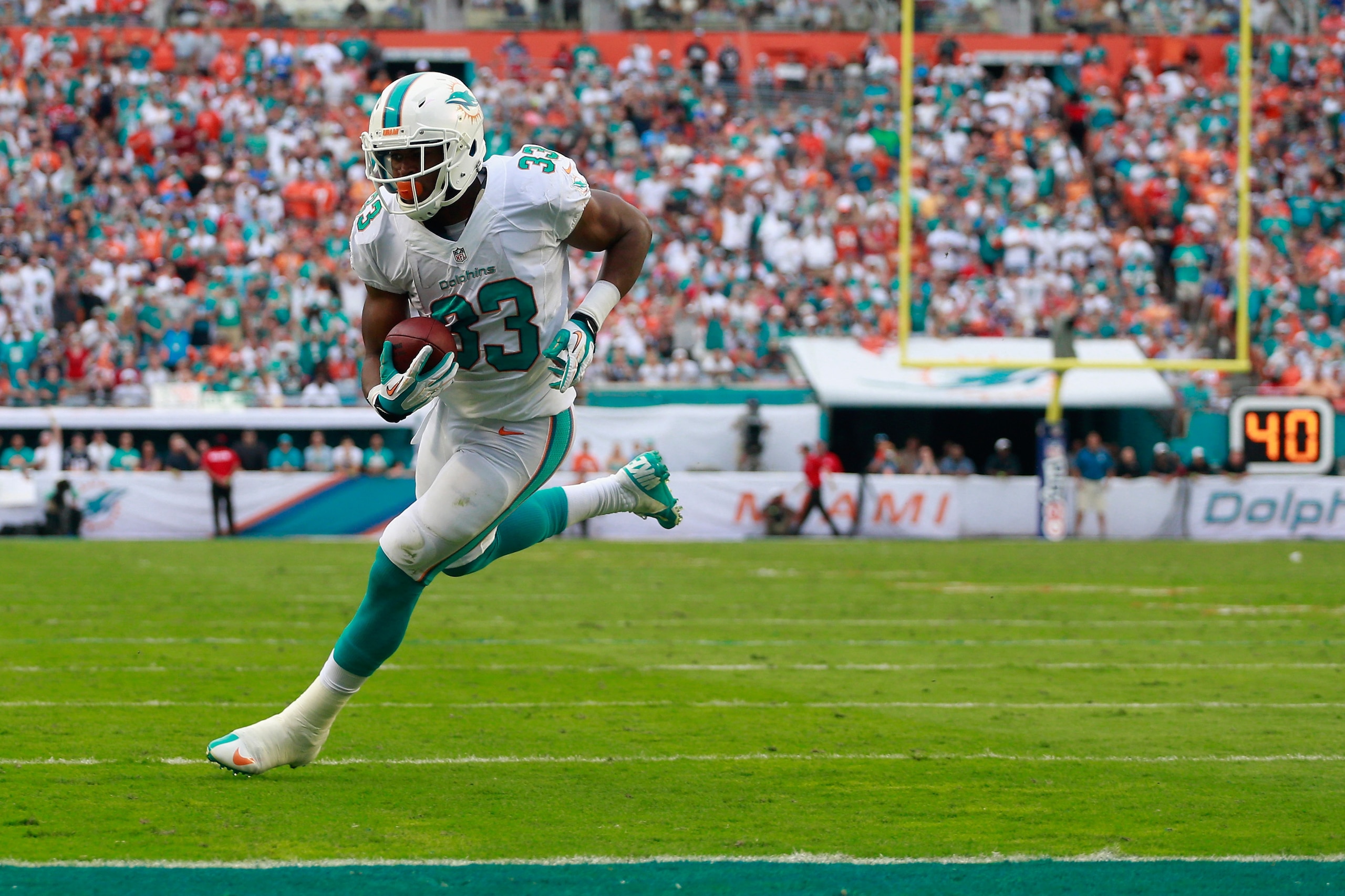 MIAMI GARDENS, FL - DECEMBER 15: Daniel Thomas #33 of the Miami Dolphins scores a touchdown in the fourth quarter against the New England Patriots looks on at Sun Life Stadium on December 15, 2013 in Miami Gardens, Florida. (Photo by Chris Trotman/Getty MIAMI GARDENS, FL - DECEMBER 15: Daniel Thomas #33 of the Miami Dolphins scores a touchdown in the fourth quarter against the New England Patriots looks on at Sun Life Stadium on December 15, 2013 in Miami Gardens, Florida. (Photo by Chris Trotman/Getty